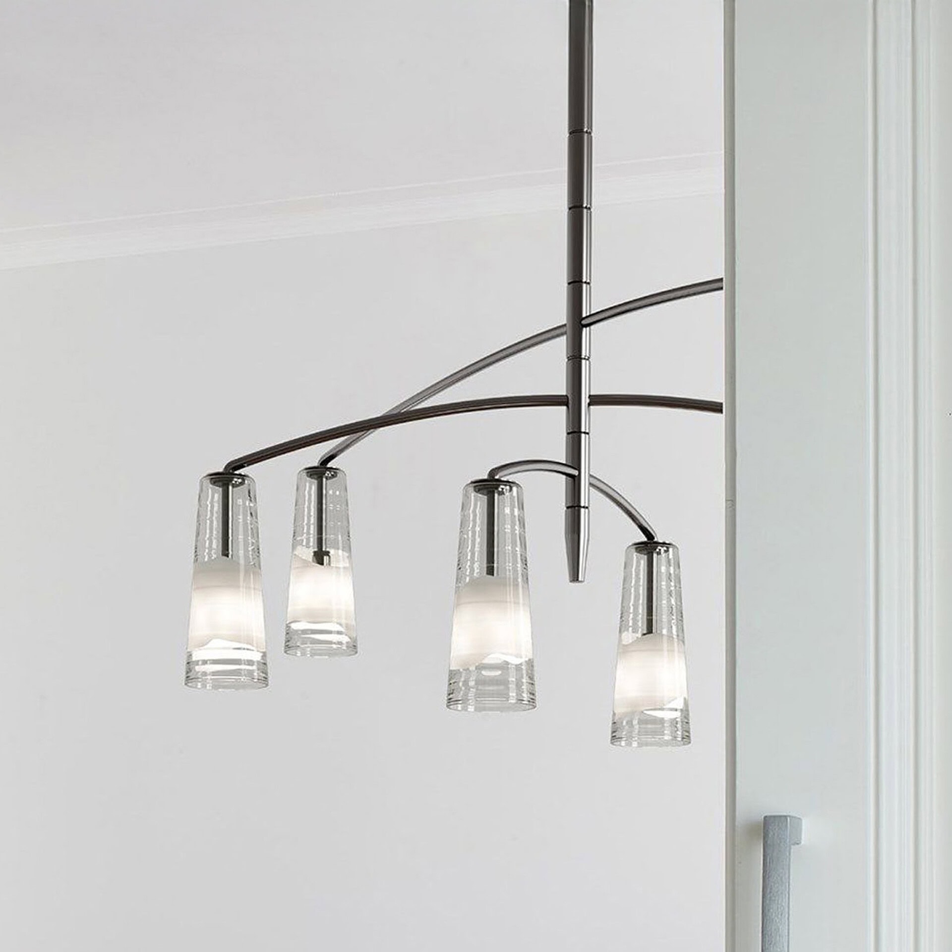 Elegant glass chandelier hanging over dining table, contemporary lighting for modern home decor.
