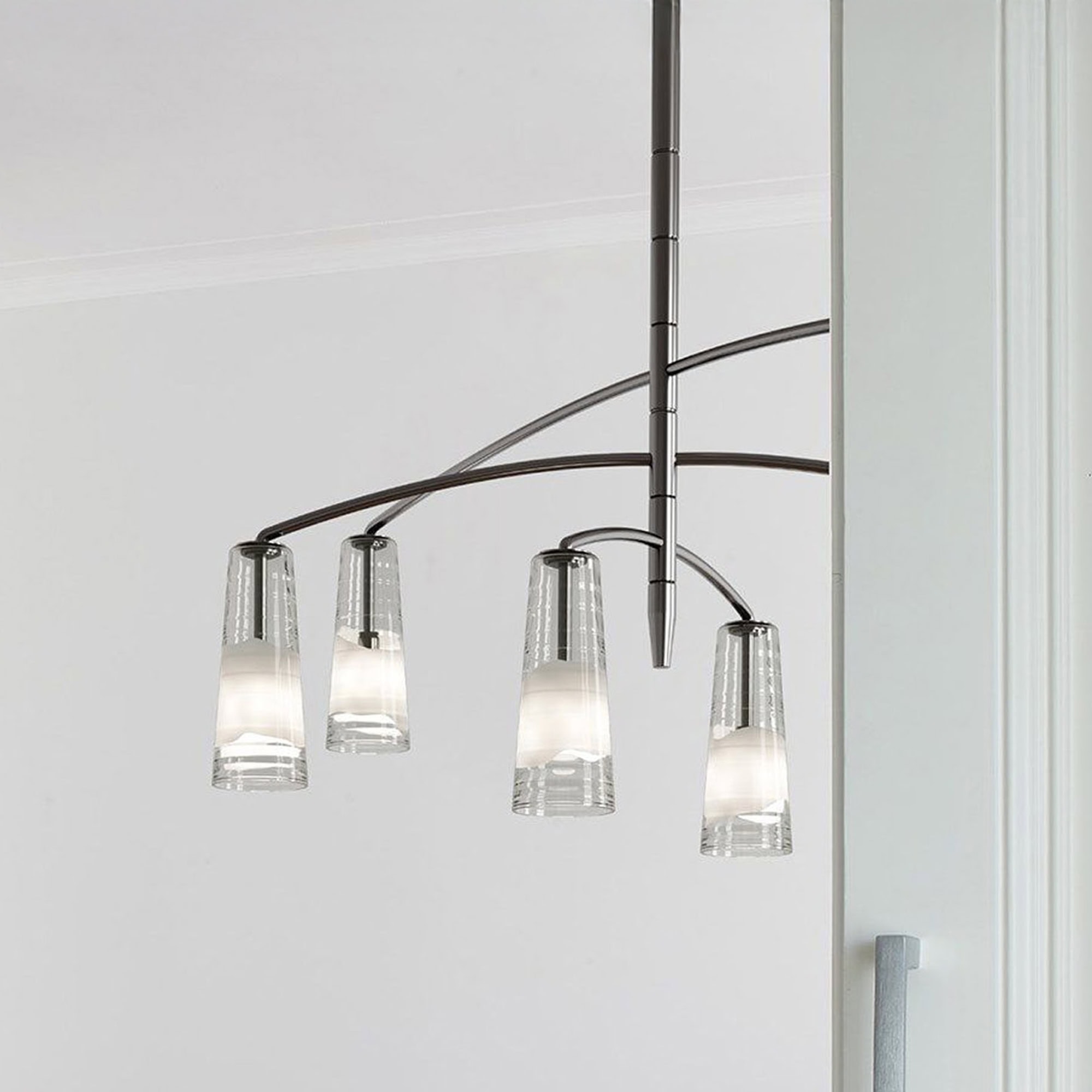 Elegant glass chandelier hanging over dining table, contemporary lighting for modern home decor.