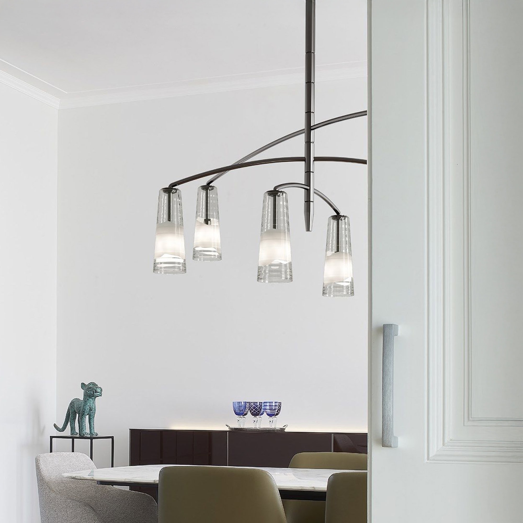 Elegant glass chandelier hanging over dining table, contemporary lighting for modern home decor.