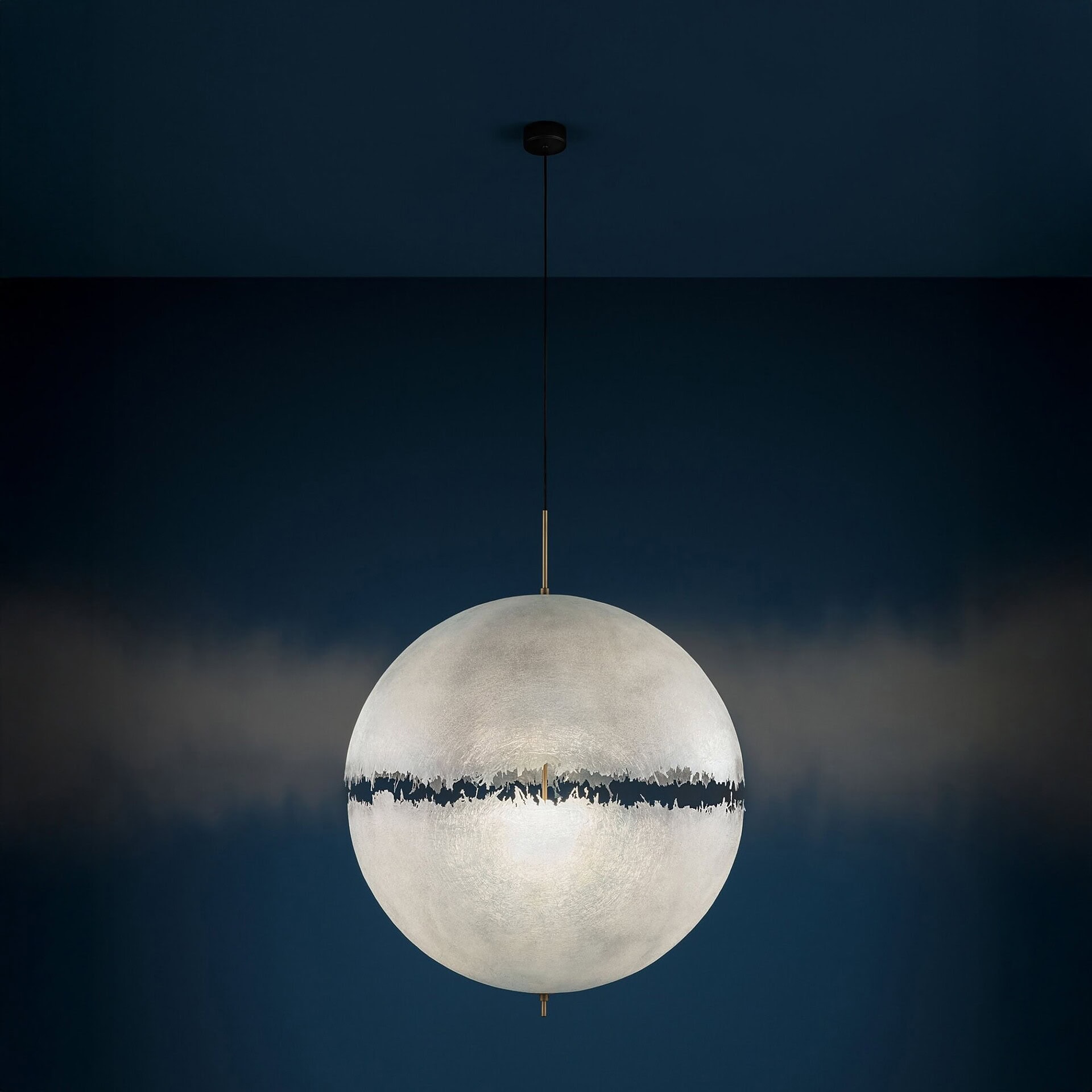 Close-up view of PostKrisi pendant light glowing softly in a dim space, emphasizing its organic sculptural detail.