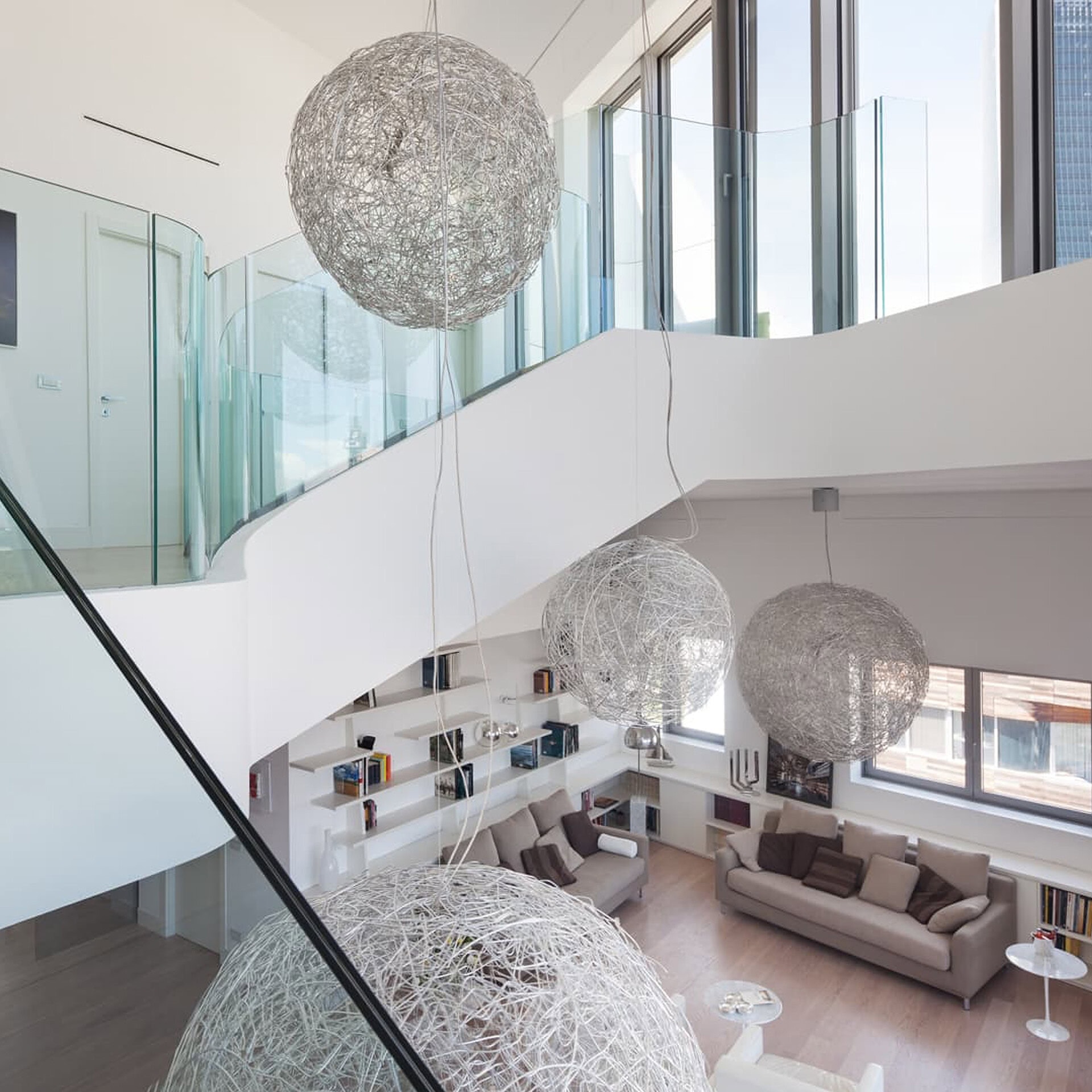 Modern interior living space with large spherical pendant lights and contemporary furniture.