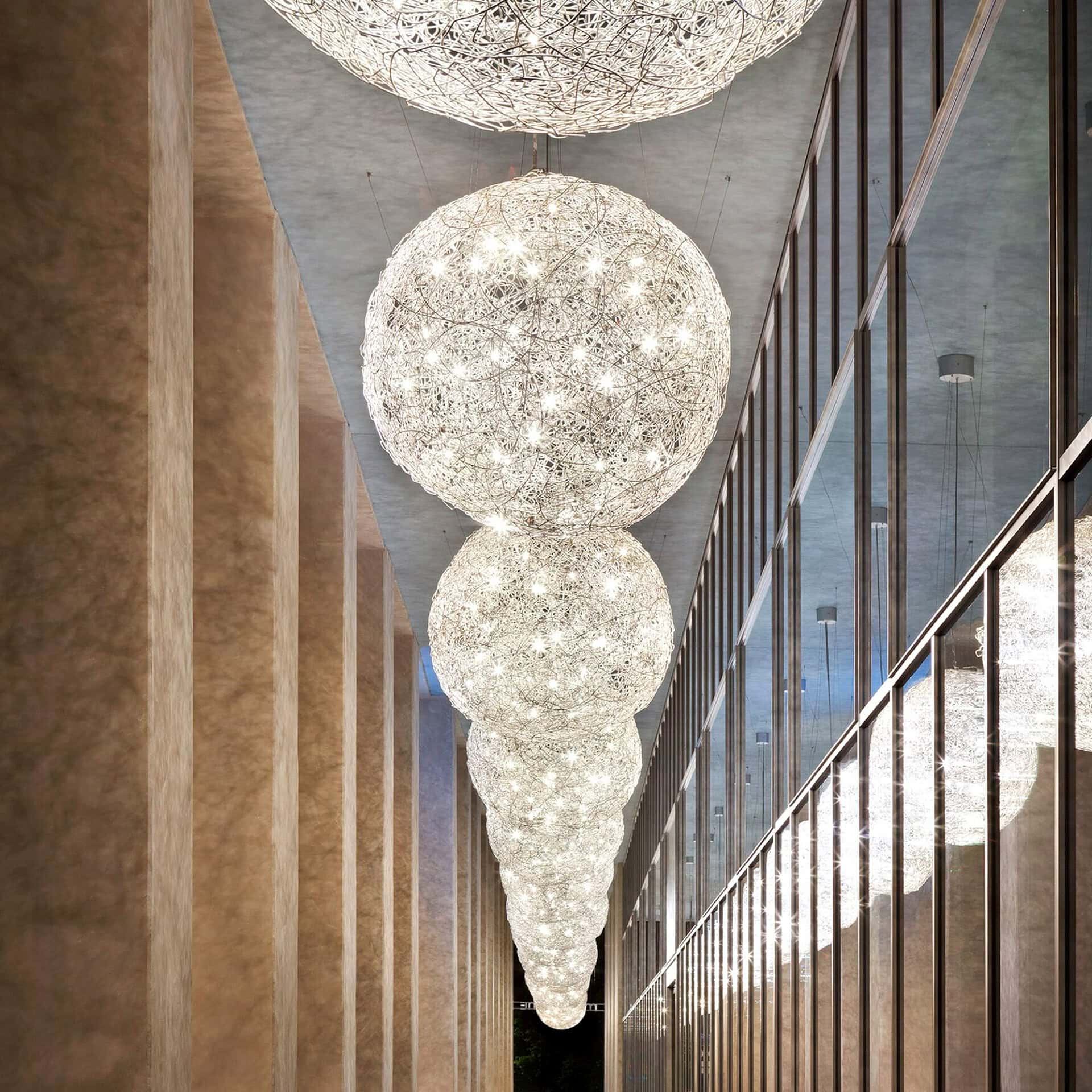 Chandelier with multiple spherical glass fixtures hanging in a sophisticated interior setting.
