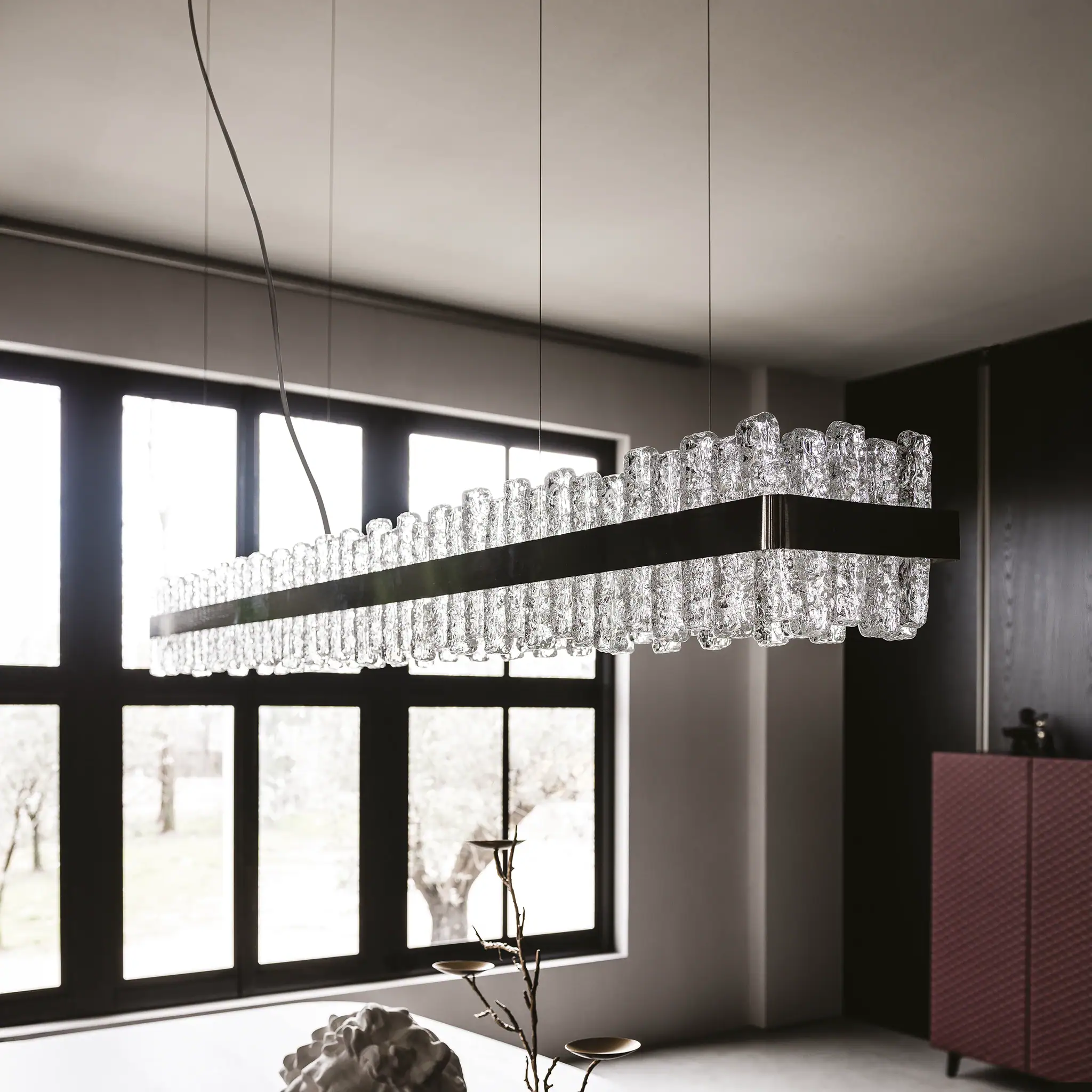 Elegant glass pendant light fixture hanging in a contemporary dining room.