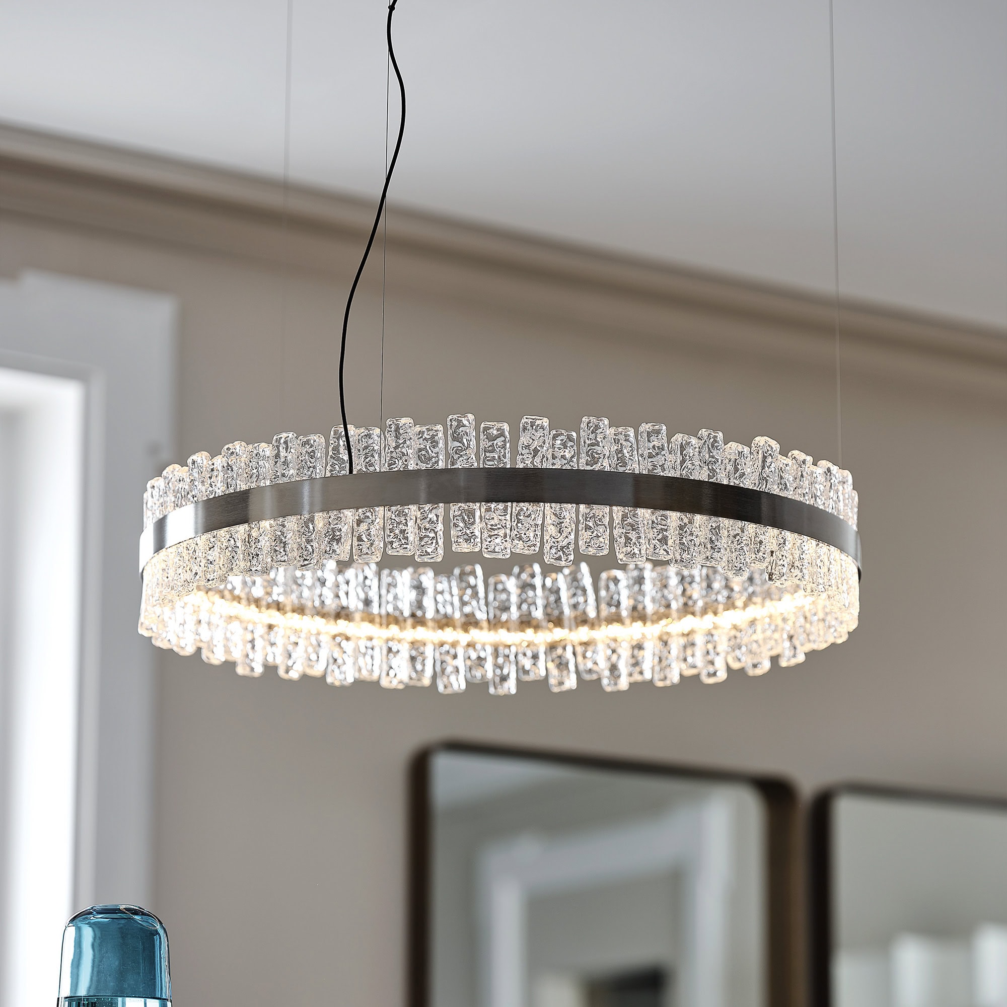 Circular Phoenix LED Handmade Glass Chandelier glowing in a contemporary living room.