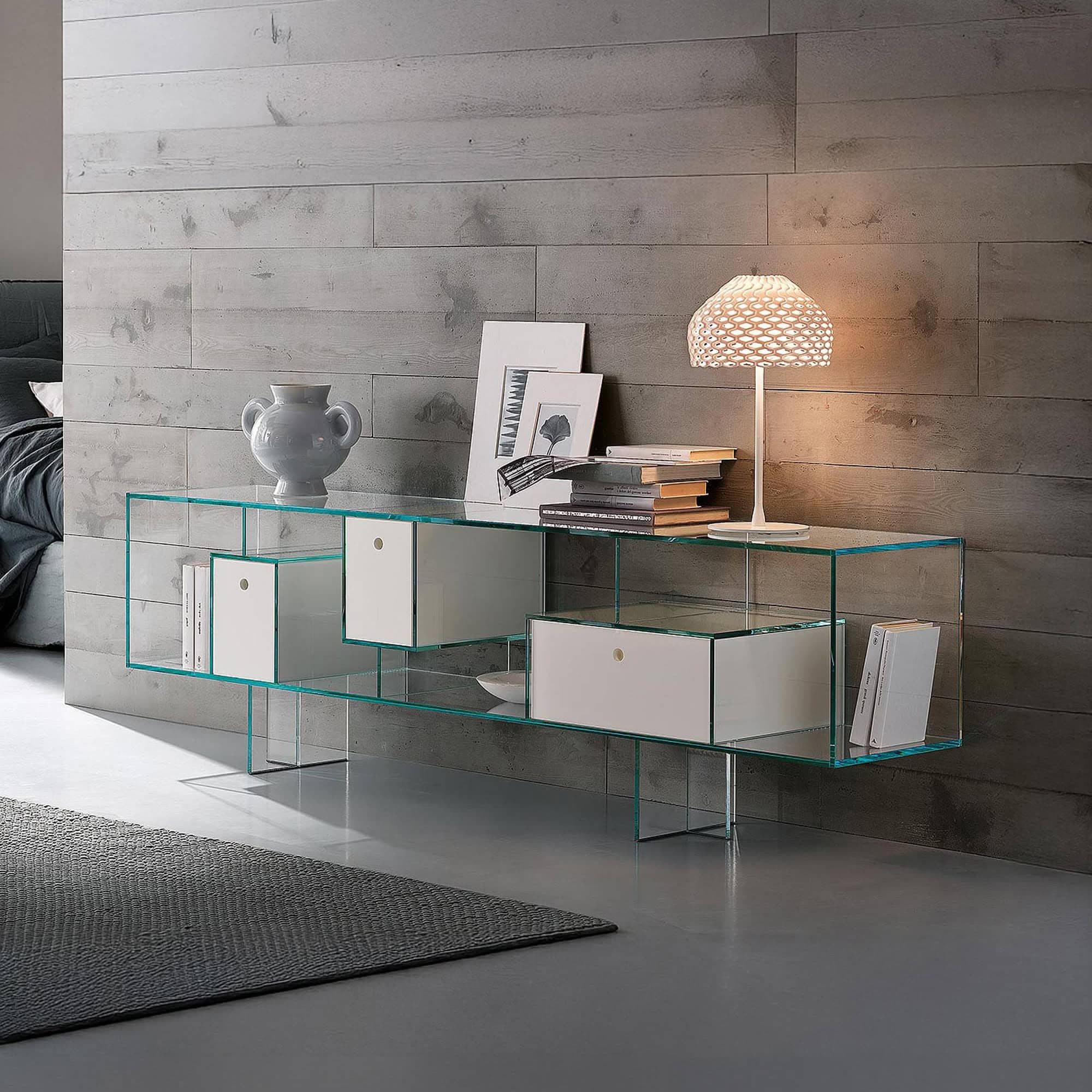 Glass sideboard with white storage compartments and decorative items.
