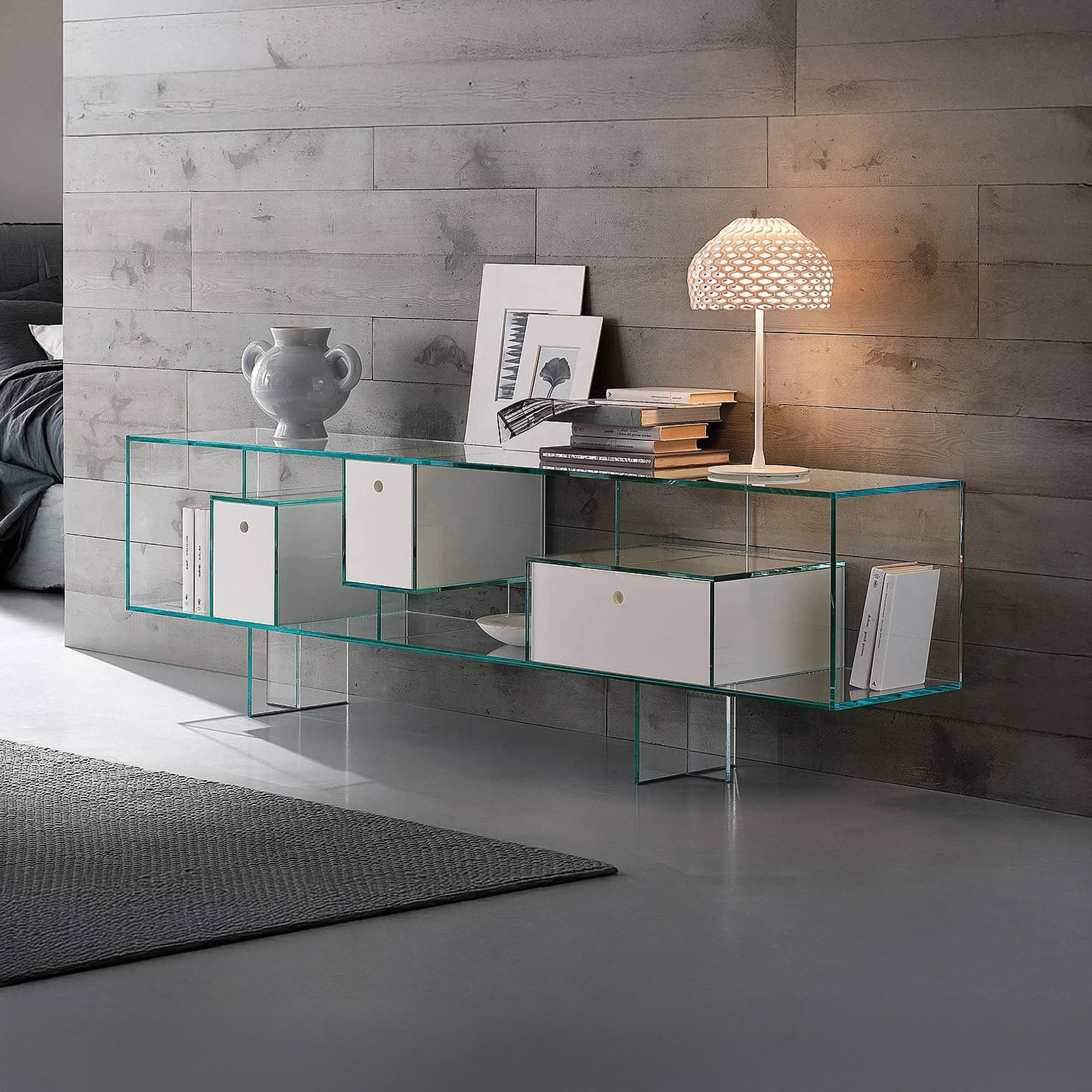 Glass sideboard with white storage compartments and decorative items.