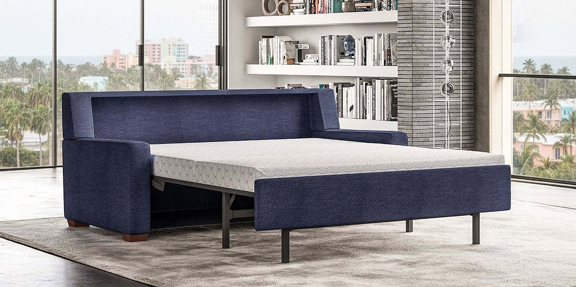 Contemporary navy sofa bed with pull-out mattress in a modern living room setting.