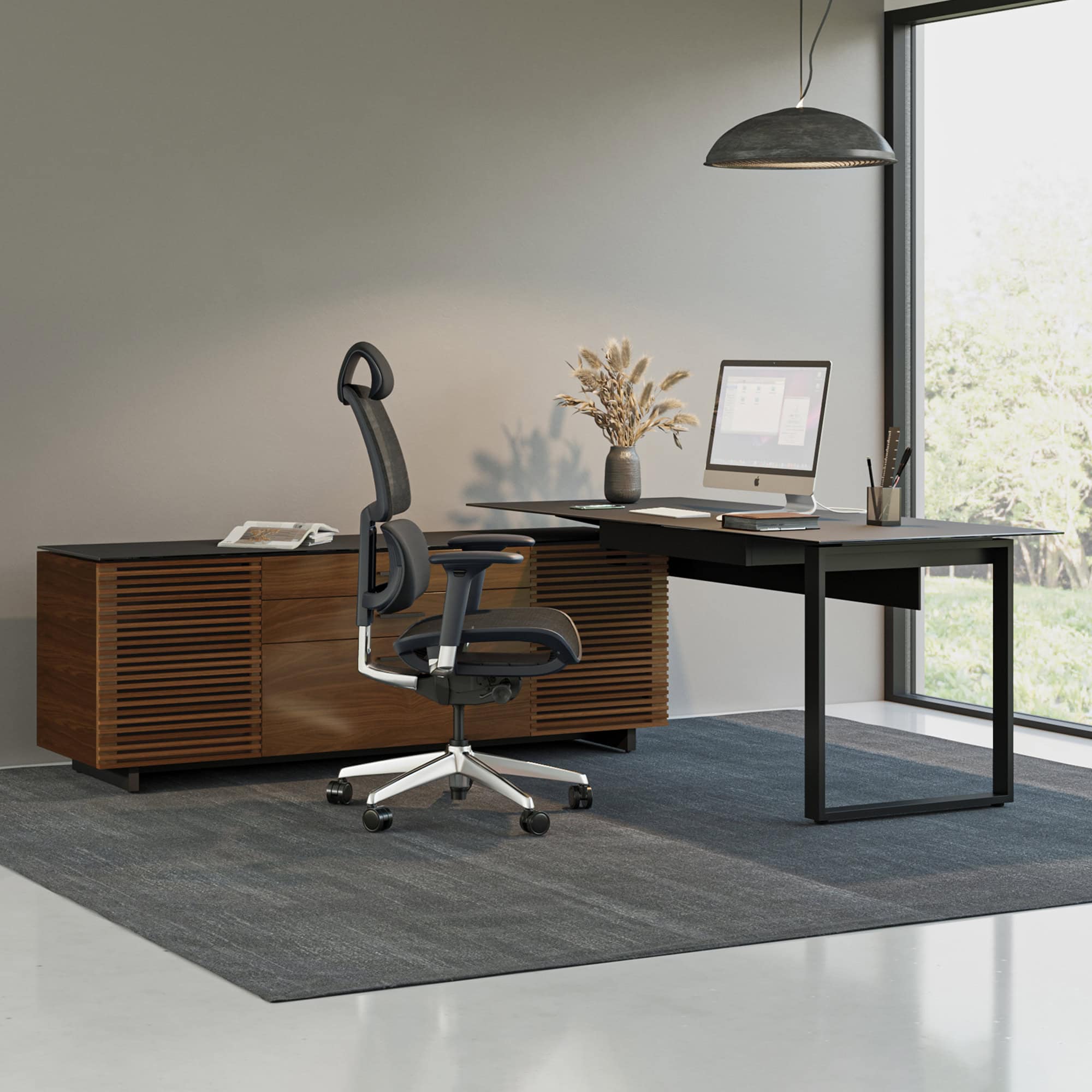 Sleek modern office desk with a black tabletop and matching ergonomic office chair, ideal for professional workspace setups.
