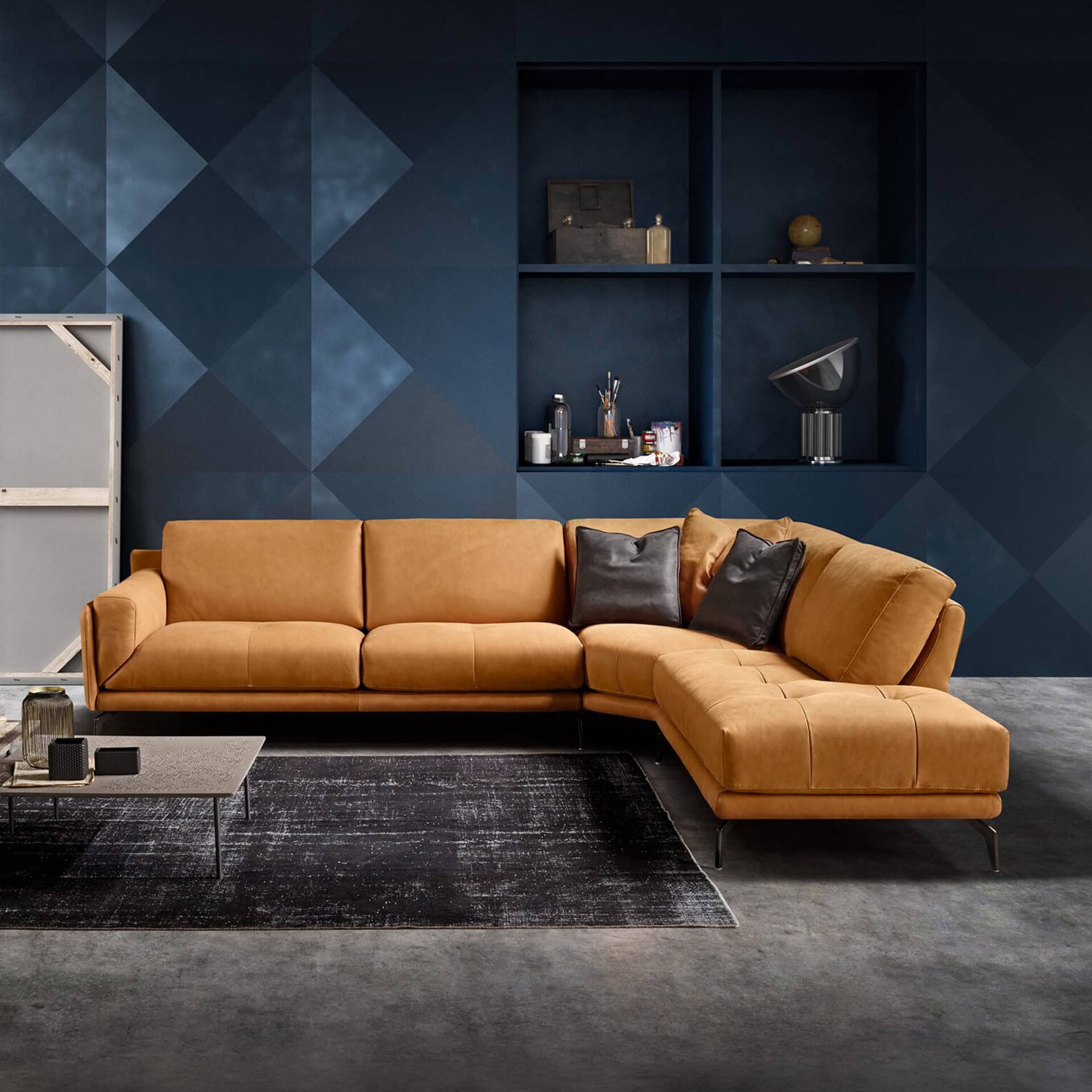 Glamour modular sectional sofa with tan upholstery and black accent pillows in a modern living room.