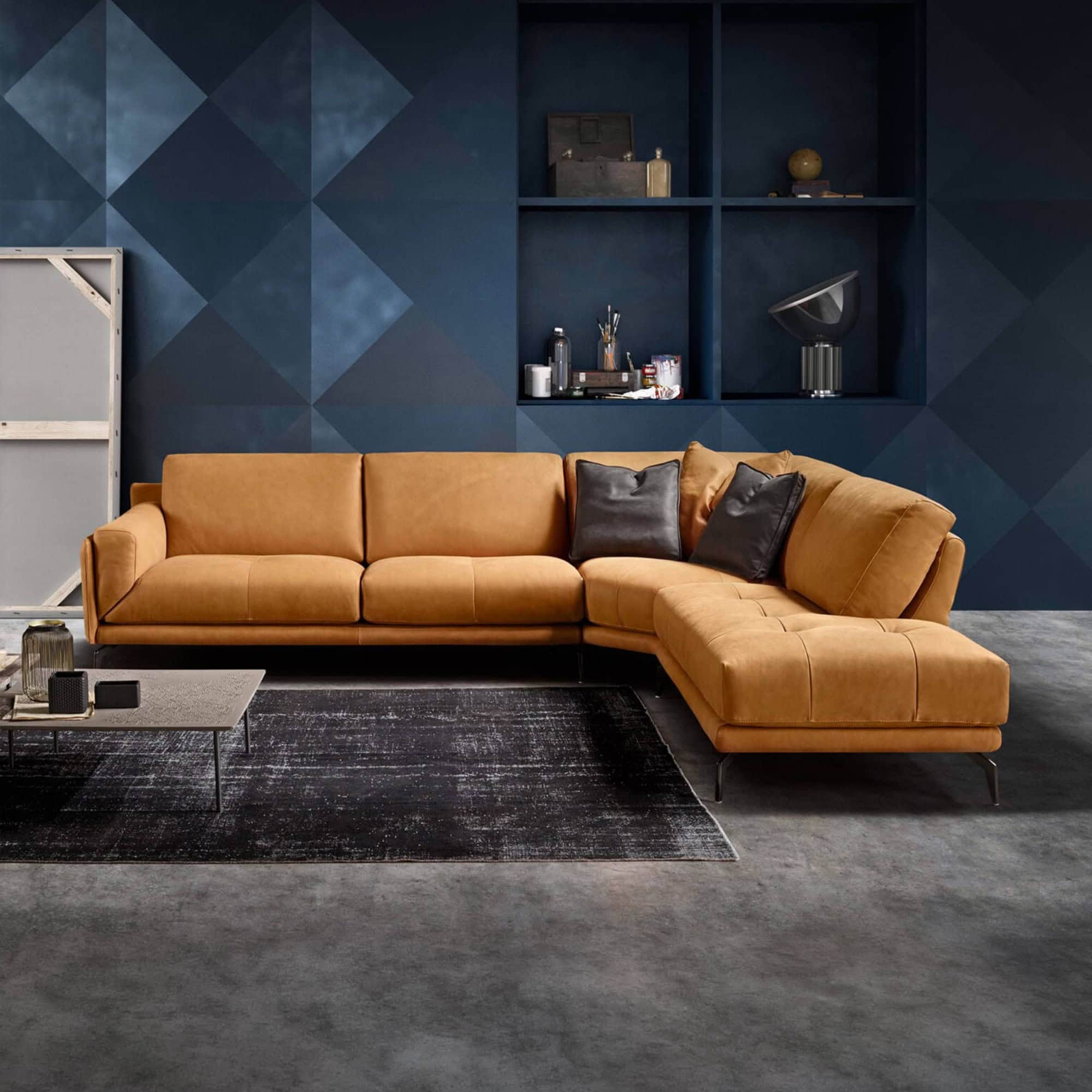 Glamour modular sectional sofa with tan upholstery and black accent pillows in a modern living room.