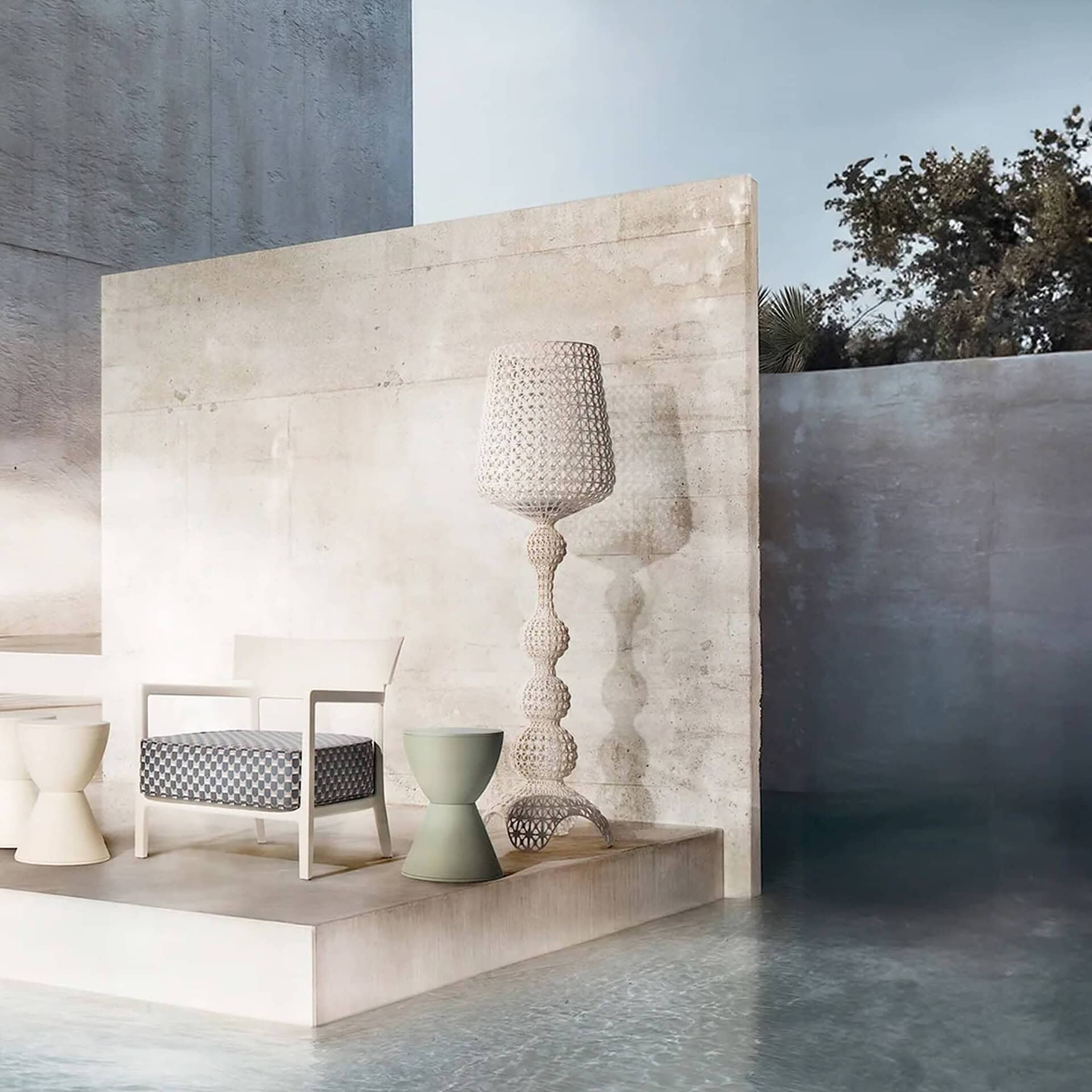 Kabuki Outdoor Floor Lamp in white finish styled against a stone wall with a sculptural chair.