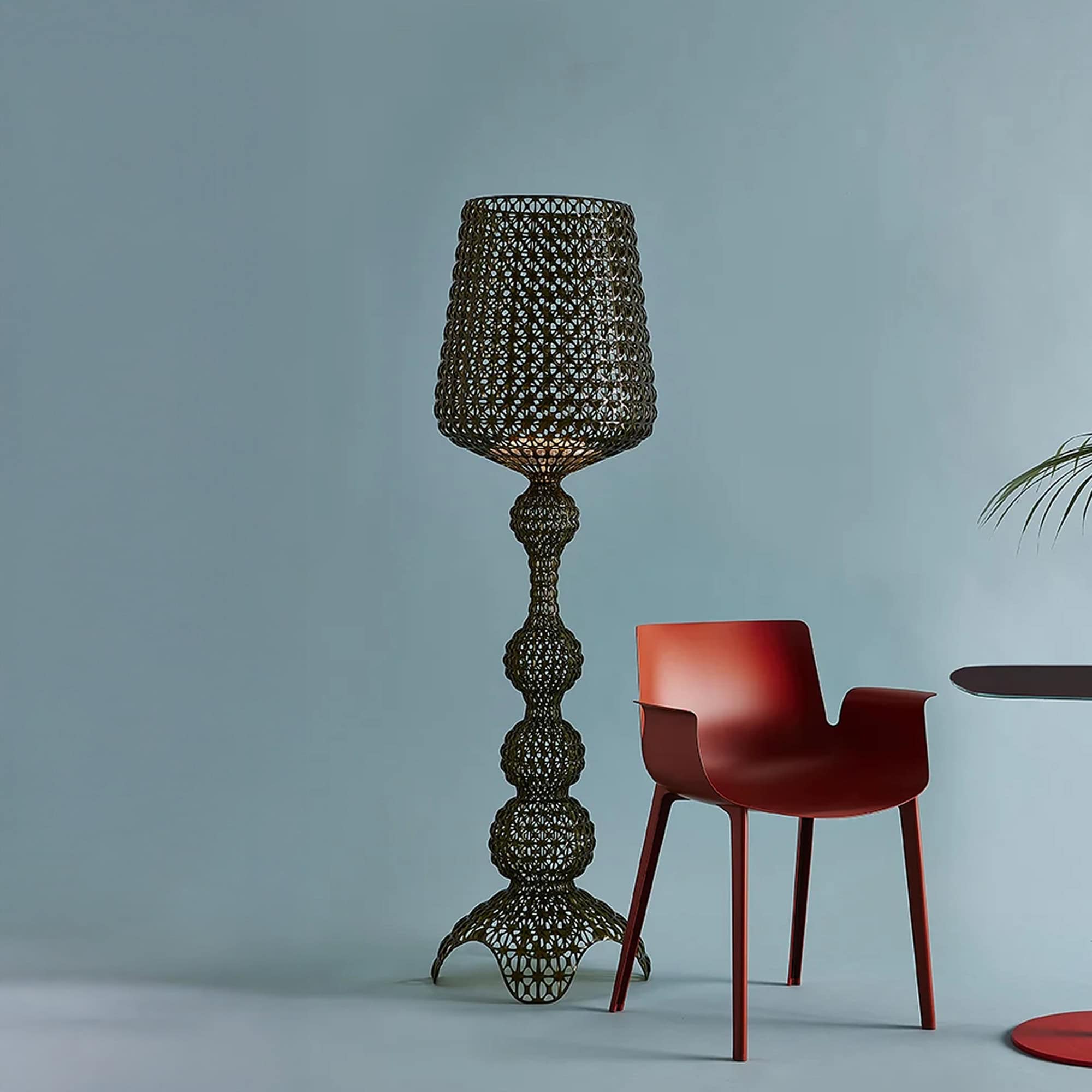 Kabuki Outdoor Floor Lamp in black finish against a blue wall with a chair.