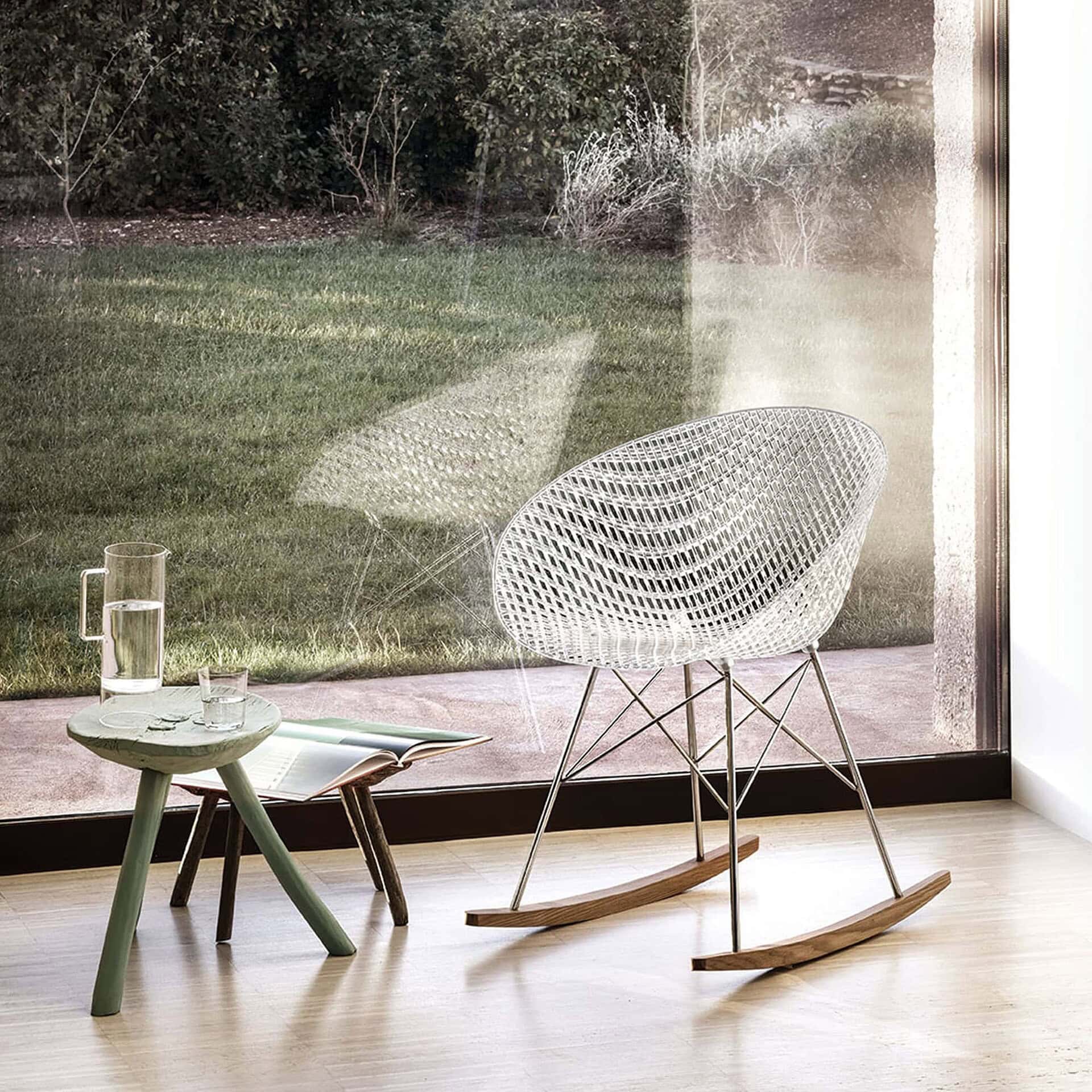 Transparent Smatrik Chair placed by a bright window with natural light streaming in.