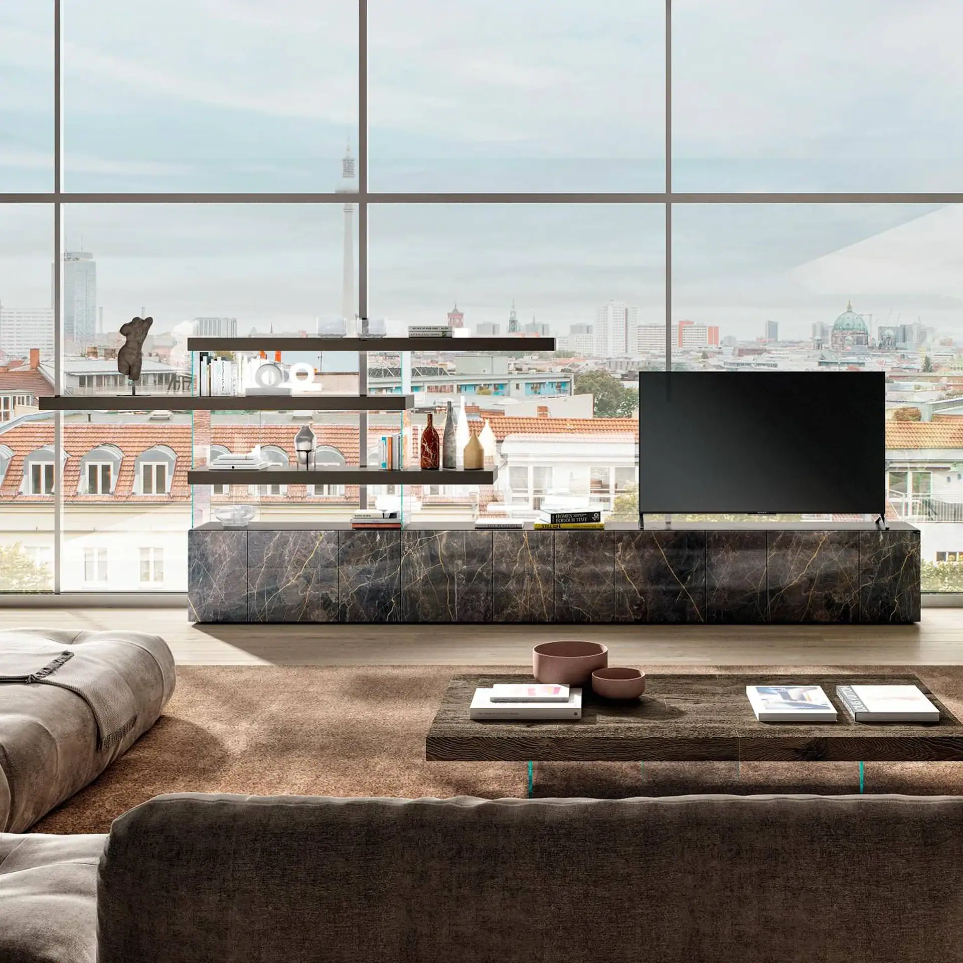 A modern living room with a large window overlooking a city, featuring a marble media console, a television, and a plush sofa.