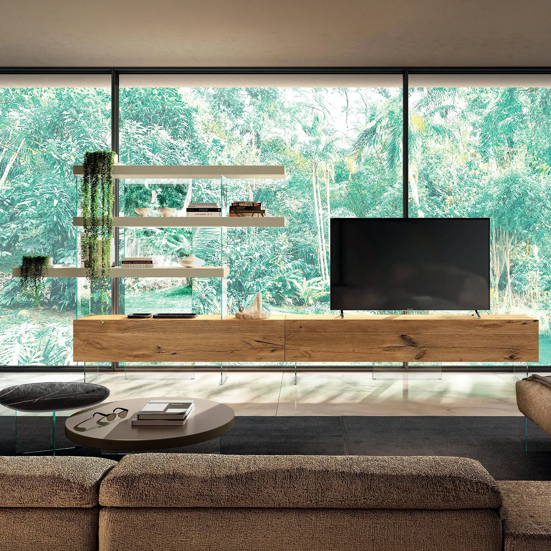 A modern living room with a wooden media console, a flat-screen TV, and white floating shelves, all set against large windows overlooking a lush green garden. A brown sectional sofa and two oval coffee tables are in the foreground.