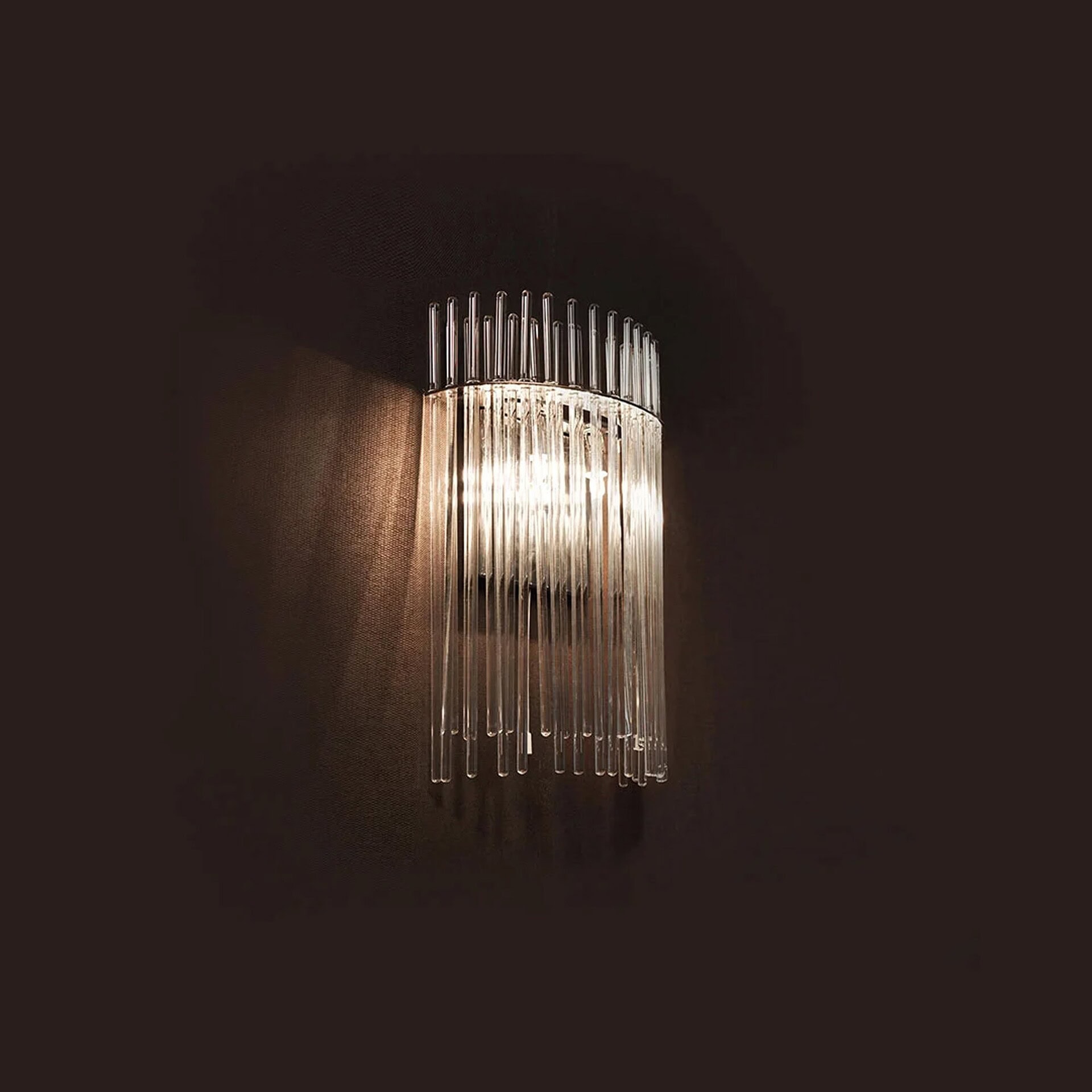 Charleston Wall Sconce glowing in a dark interior, highlighting its Murano glass shade and polished frame.
