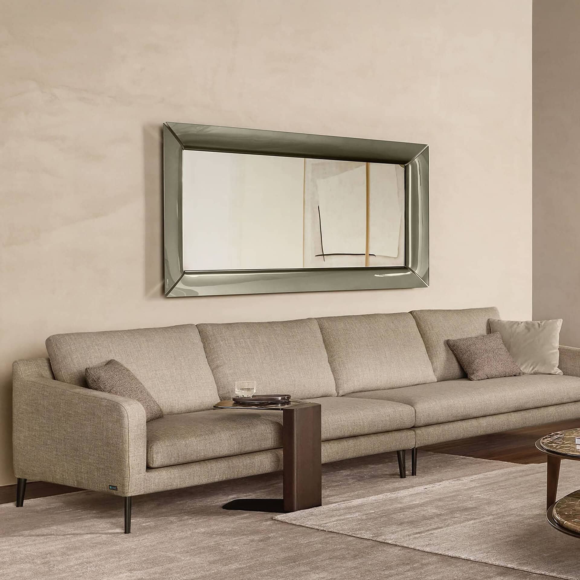Horizontal Caadre Mirror above a sofa in a contemporary living room setting.