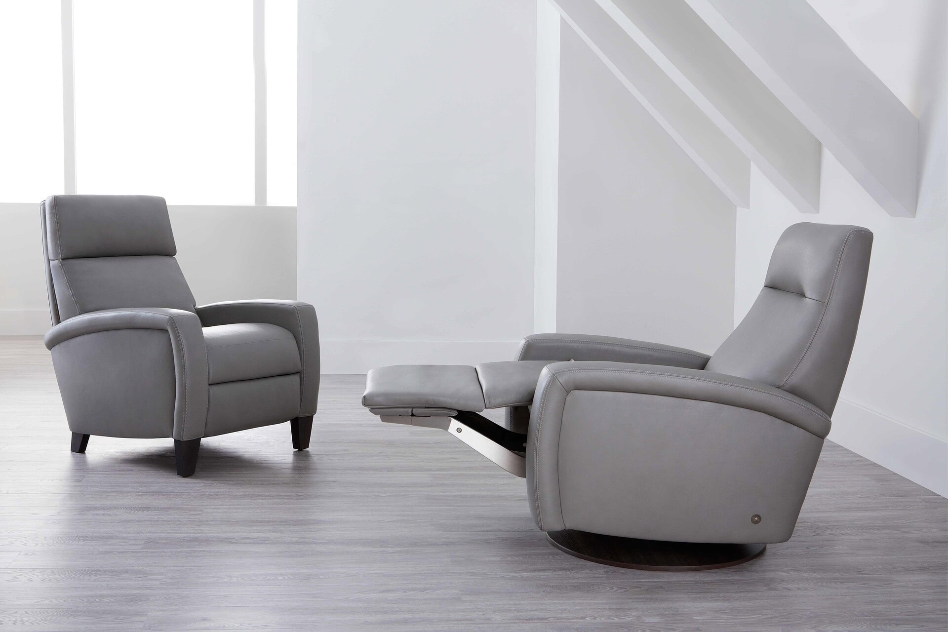 Luxurious gray recliner and matching armchair in modern minimalist setting.