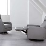 Comfortable gray leather lounge chairs with a matching ottoman for modern living spaces.