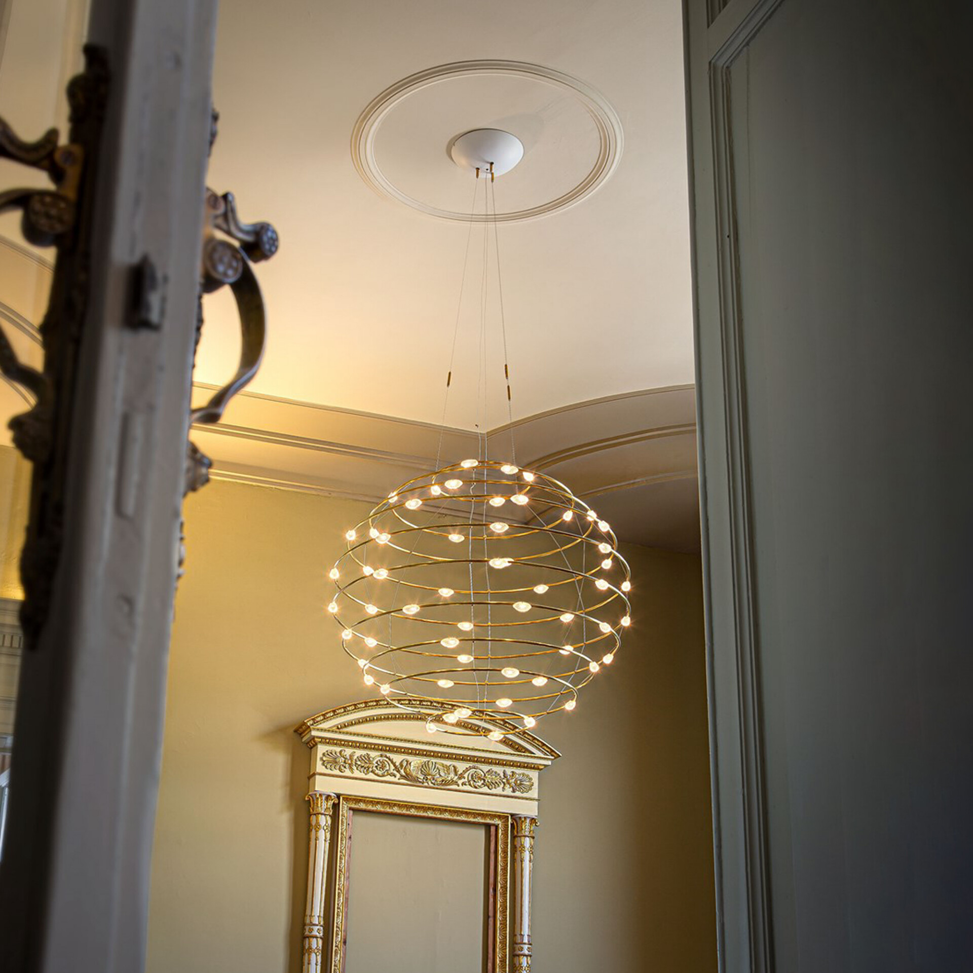 Pendant light fixture with a spherical, layered design hanging from a ceiling medallion.