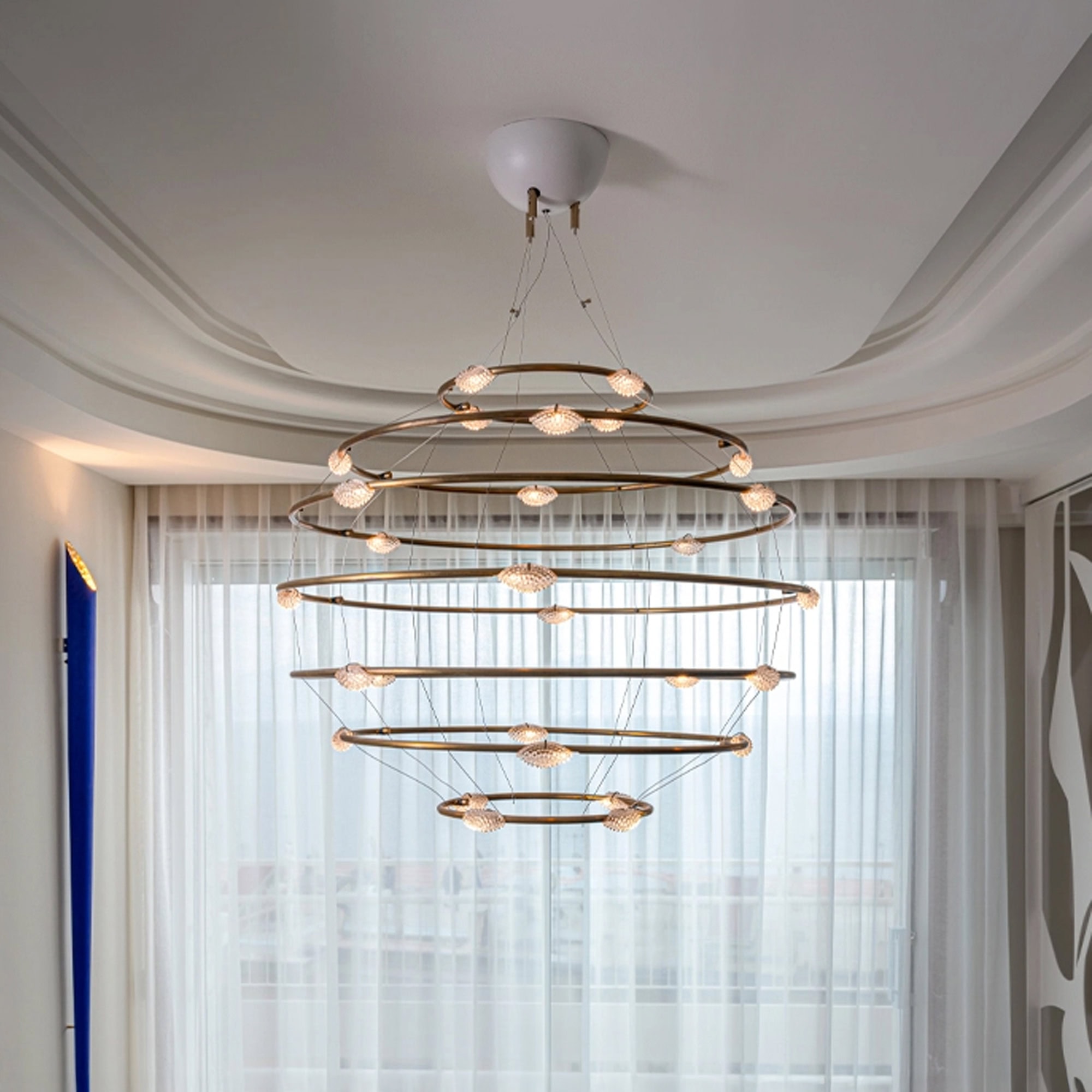 Modern circular chandelier with multiple rings and integrated lighting, enhancing contemporary livin.