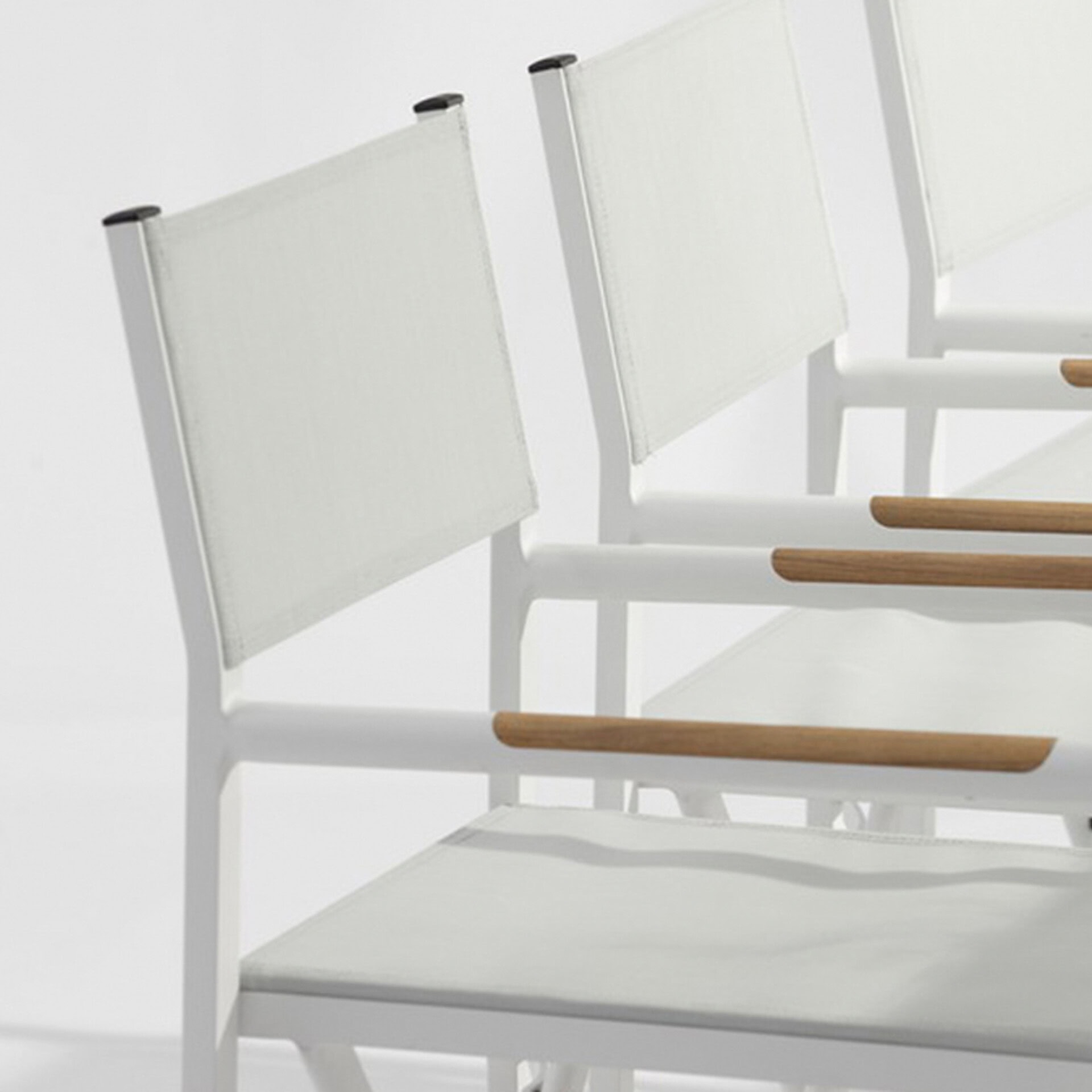 Set of sleek white dining chairs with wooden armrests for contemporary dining rooms.