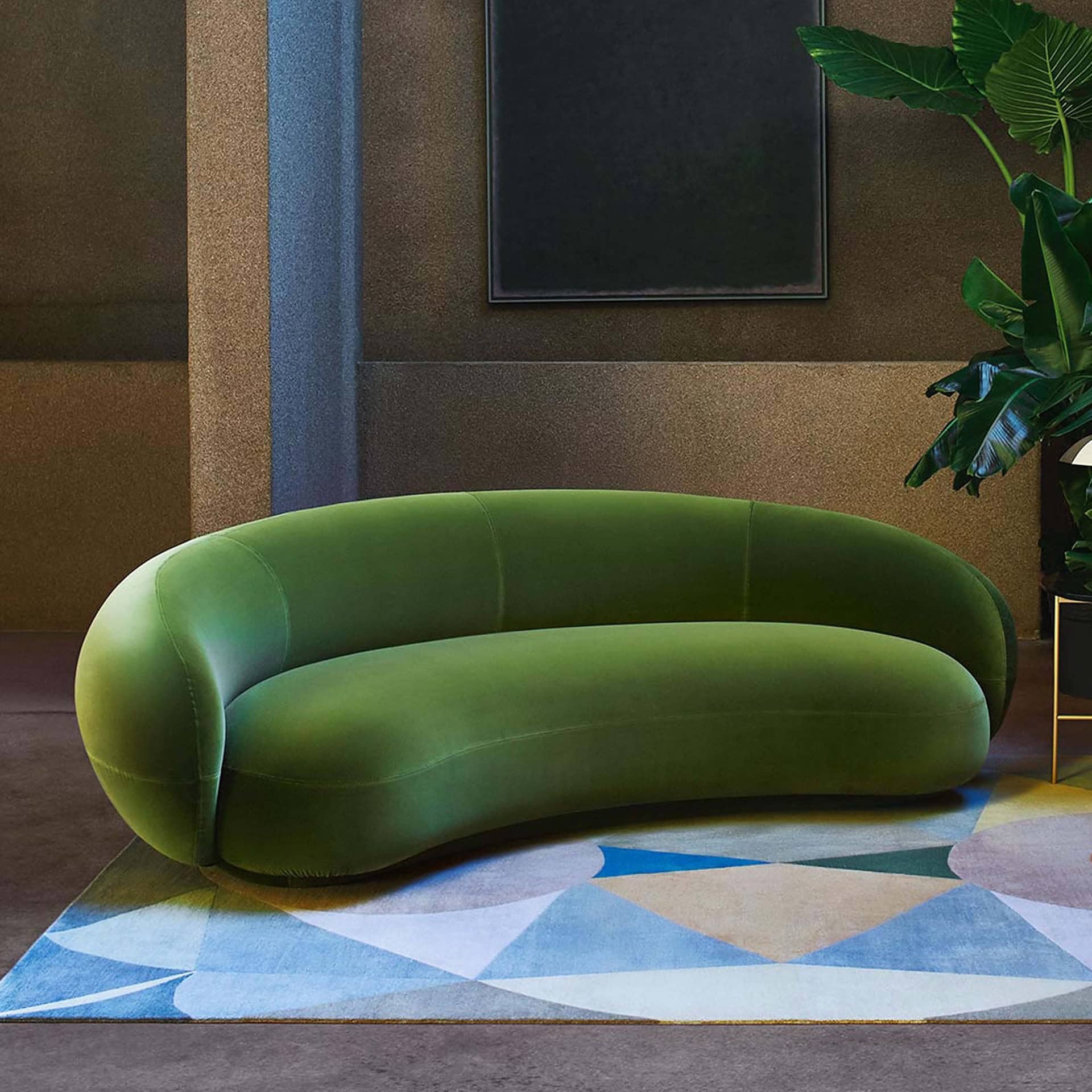 Vivid green velvet sofa in modern living room with geometric rug and lush plant.