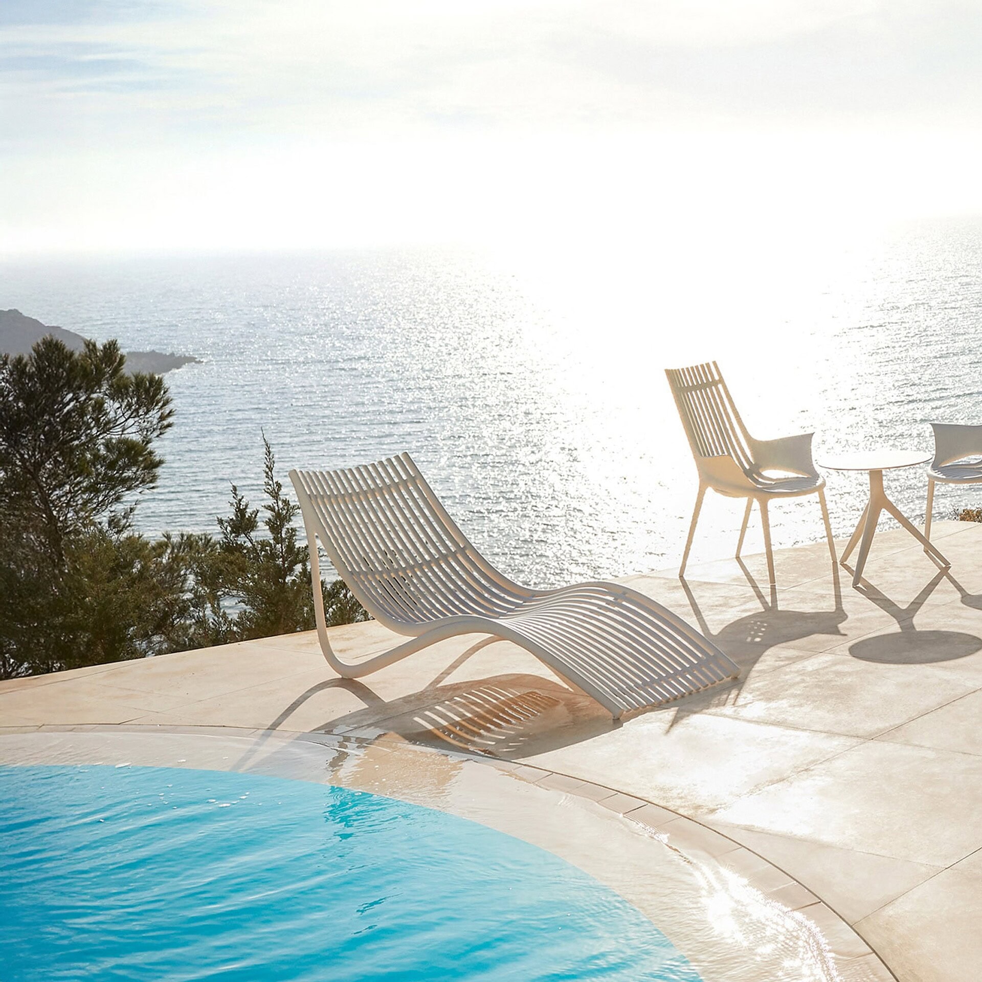 Vondom Ibiza Sun Lounger by the pool with chairs, overlooking the sea