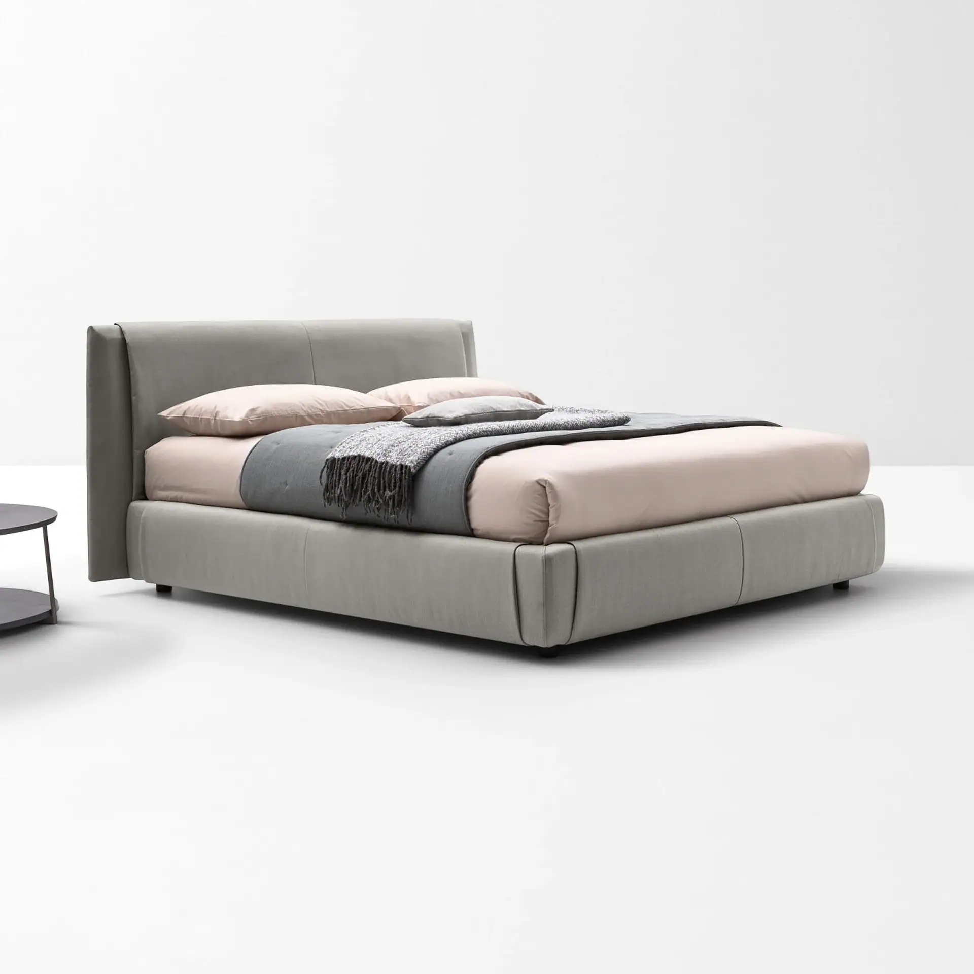 Sklar bed with upholstered headboard in neutral tones in a minimalist room.