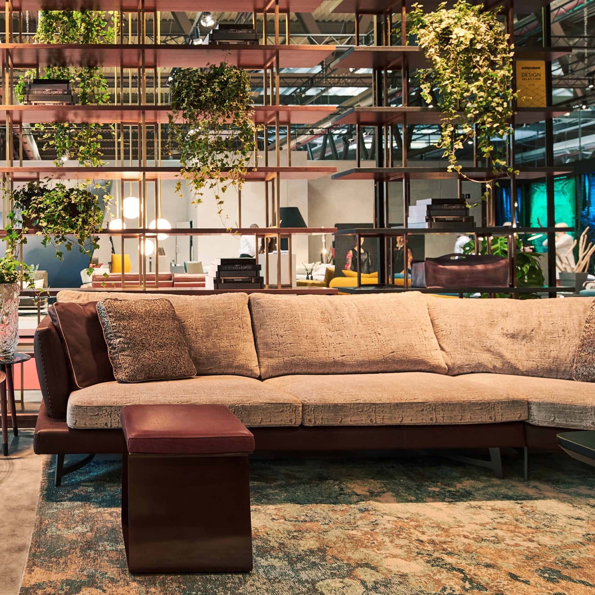 Soft beige sectional sofa with decorative pillows in modern furniture showroom.