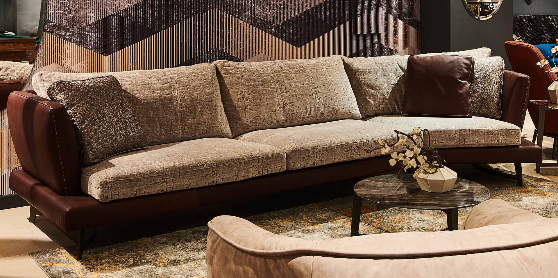 Modern upholstered sofa with contrasting leather accents in a stylish living room setting.