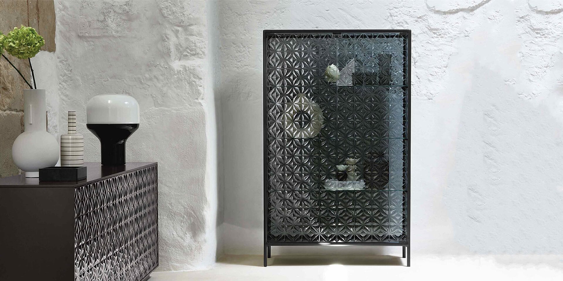 Elegant black metal display cabinet with geometric pattern, perfect for modern living room decor.