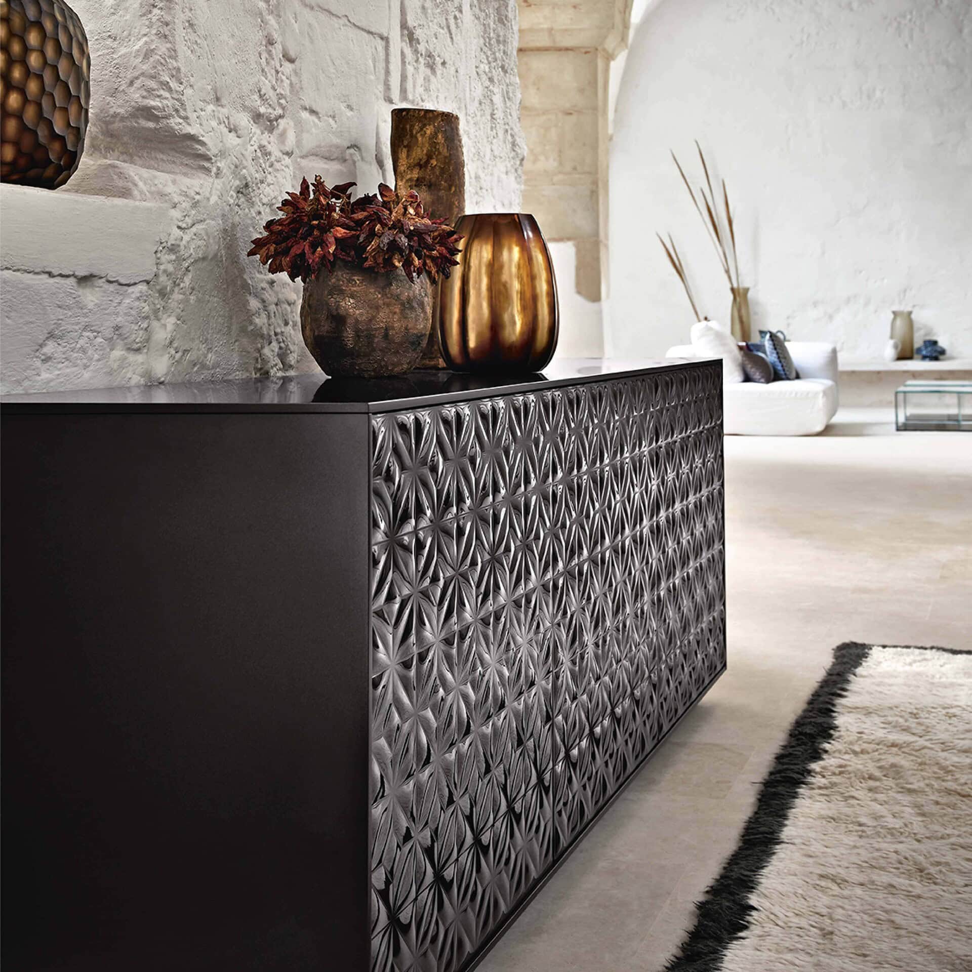 Elegant black textured sideboard with decorative vases and earthy accents for modern living rooms.