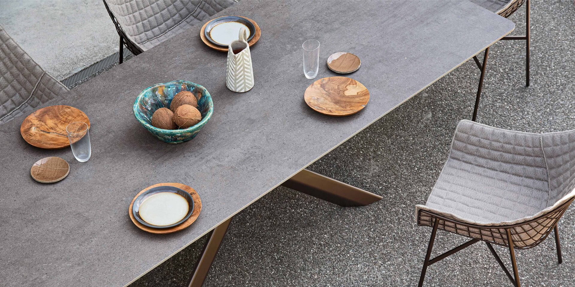 Modern outdoor dining table with stylish chairs and decorative tableware for contemporary patios.