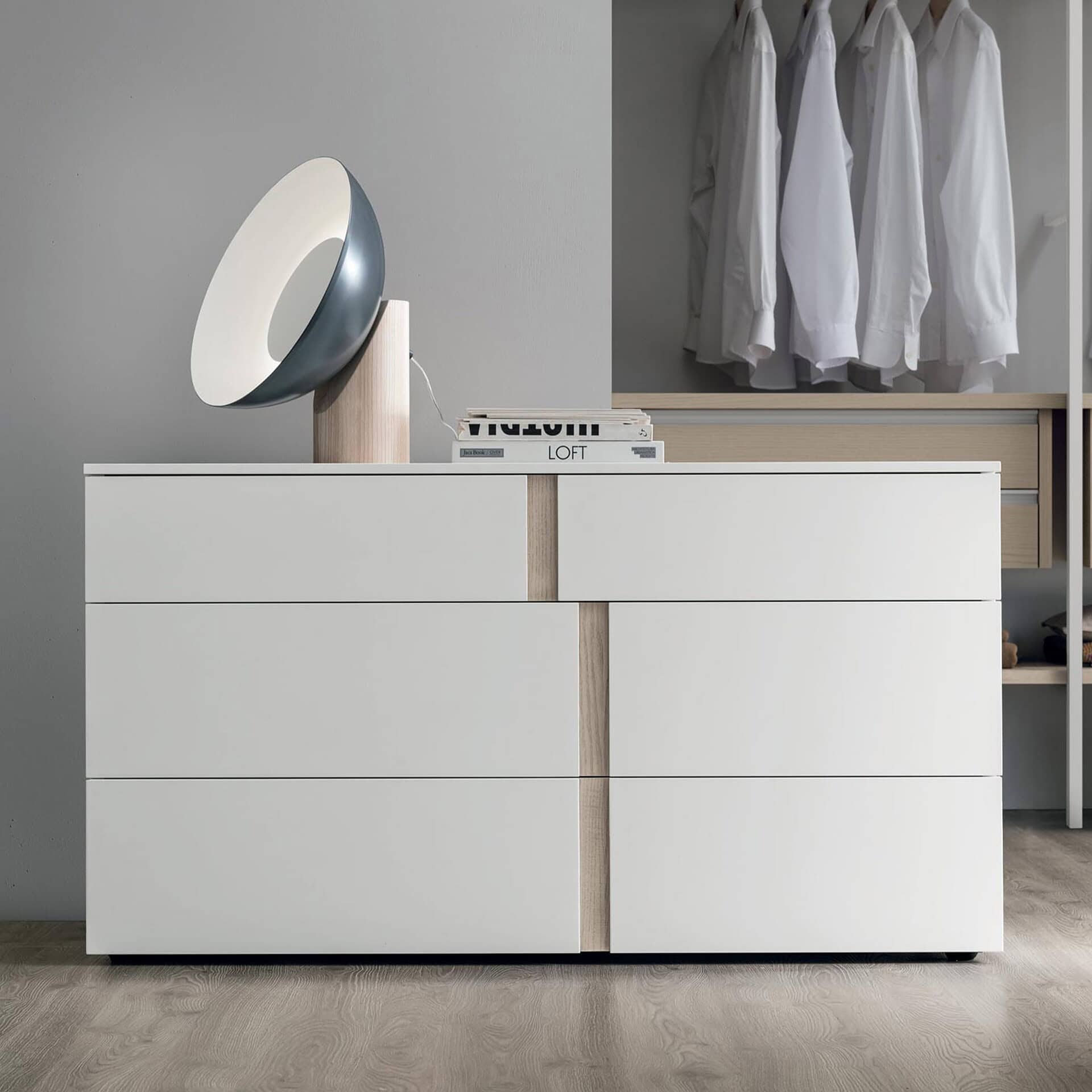 Modern white dresser with minimalist design and wood accents for stylish bedroom storage.