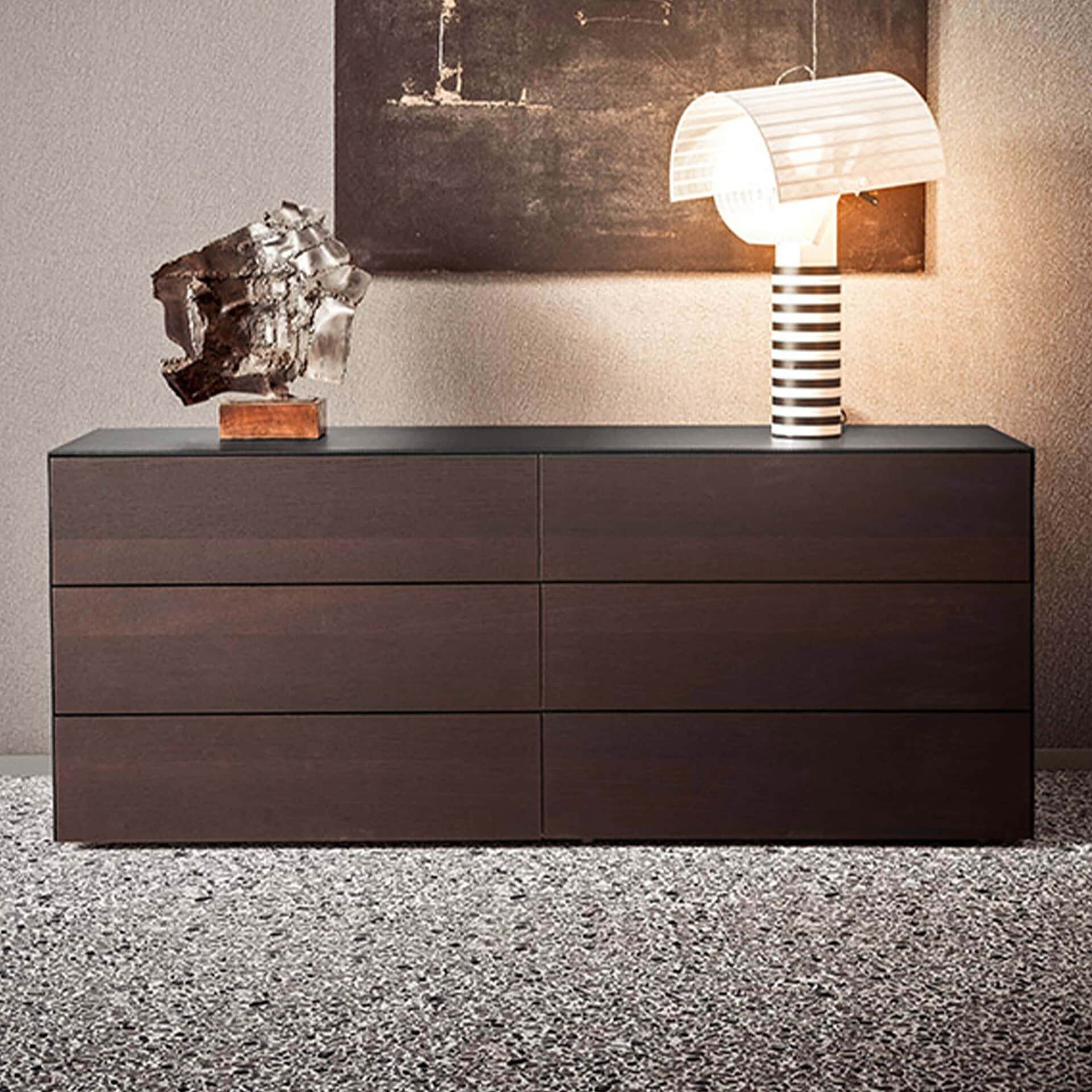 Sleek dark wood sideboard with decorative sculpture and modern striped lamp, stylish storage solutions.
