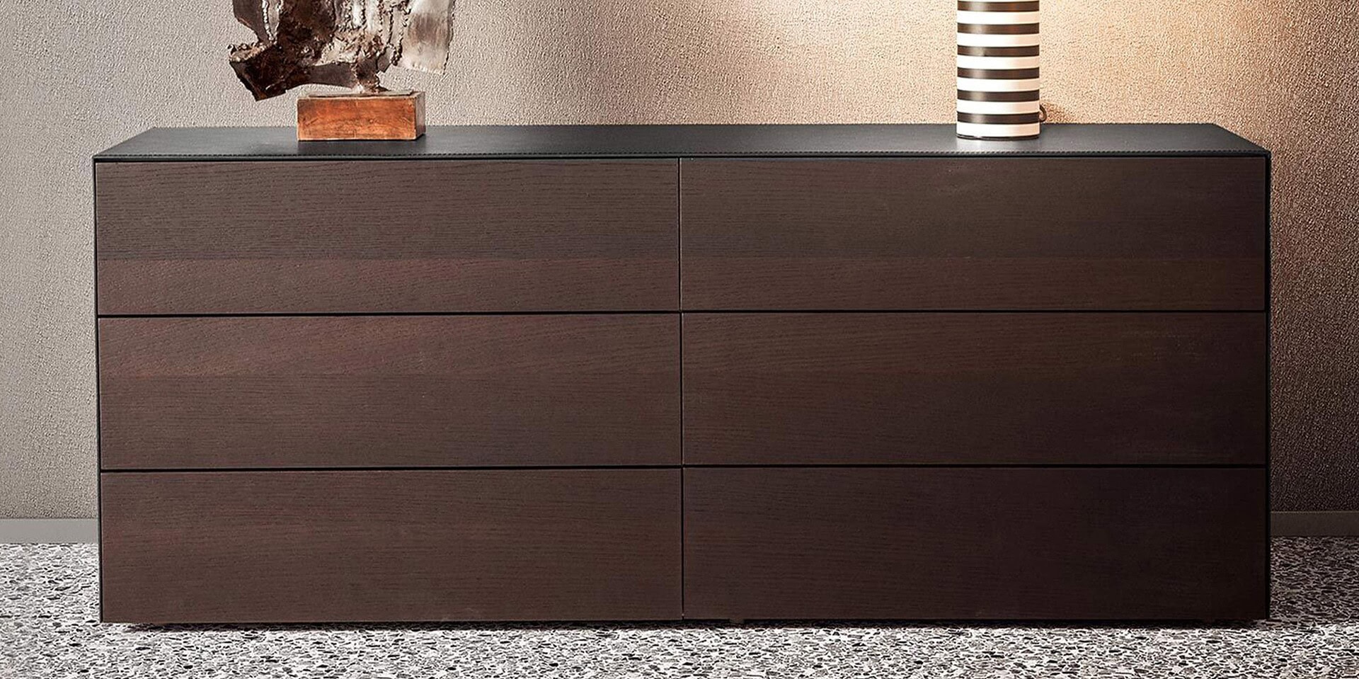 Sleek dark wood modern dresser with six drawers, stylish decor accents on top.