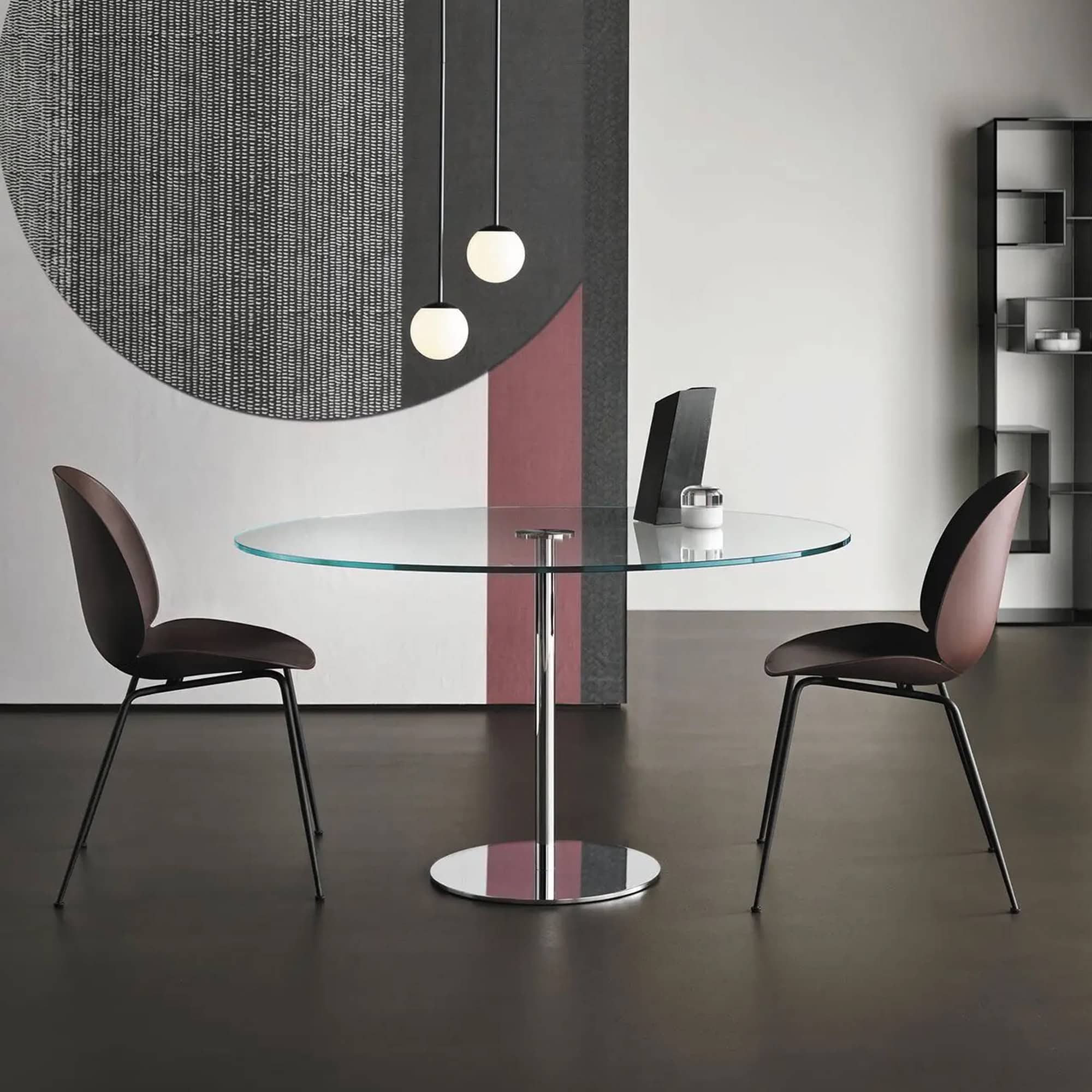 Modern glass dining table with two stylish chairs in a contemporary interior setting.