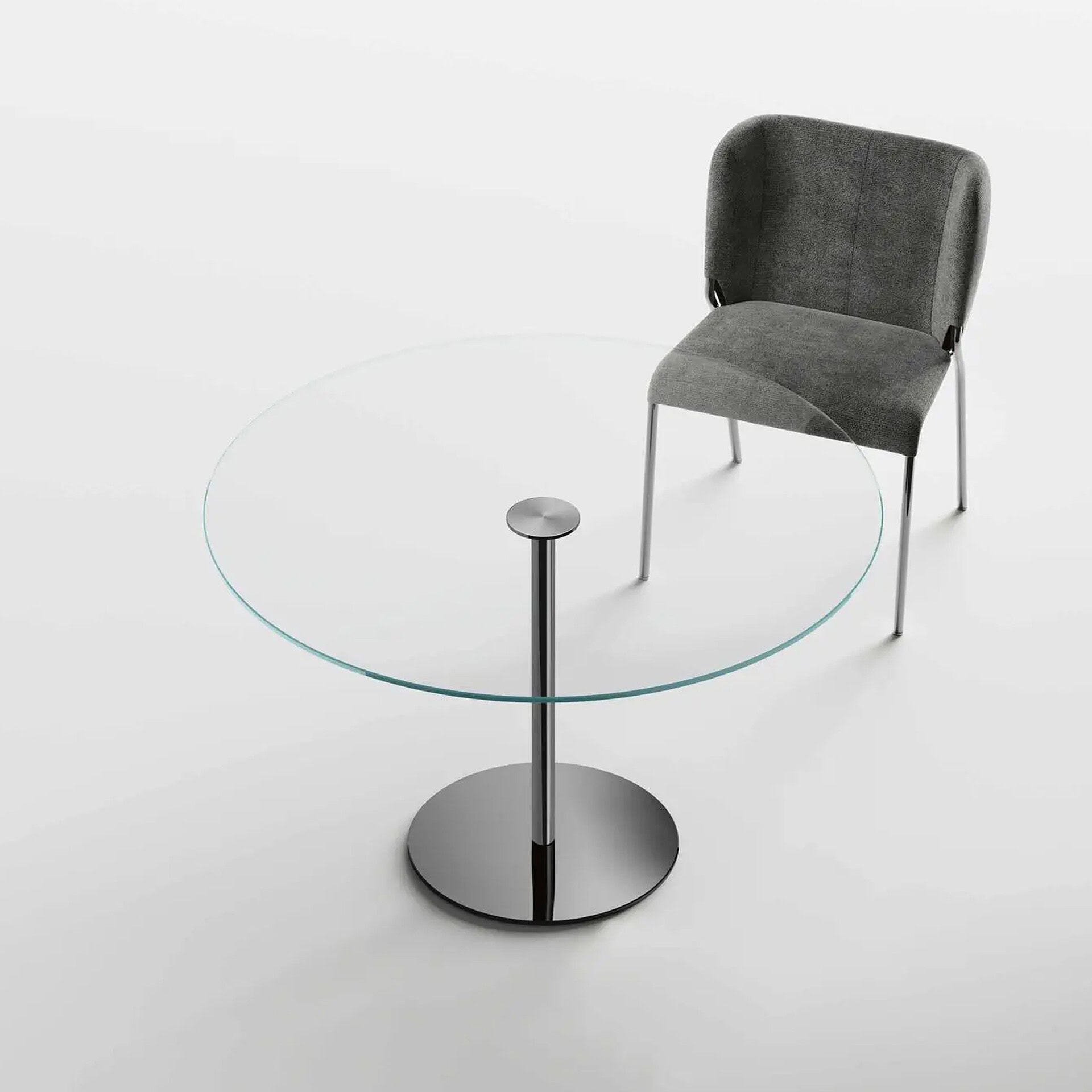 Modern glass round table paired with a grey upholstered chair for stylish office or dining space.