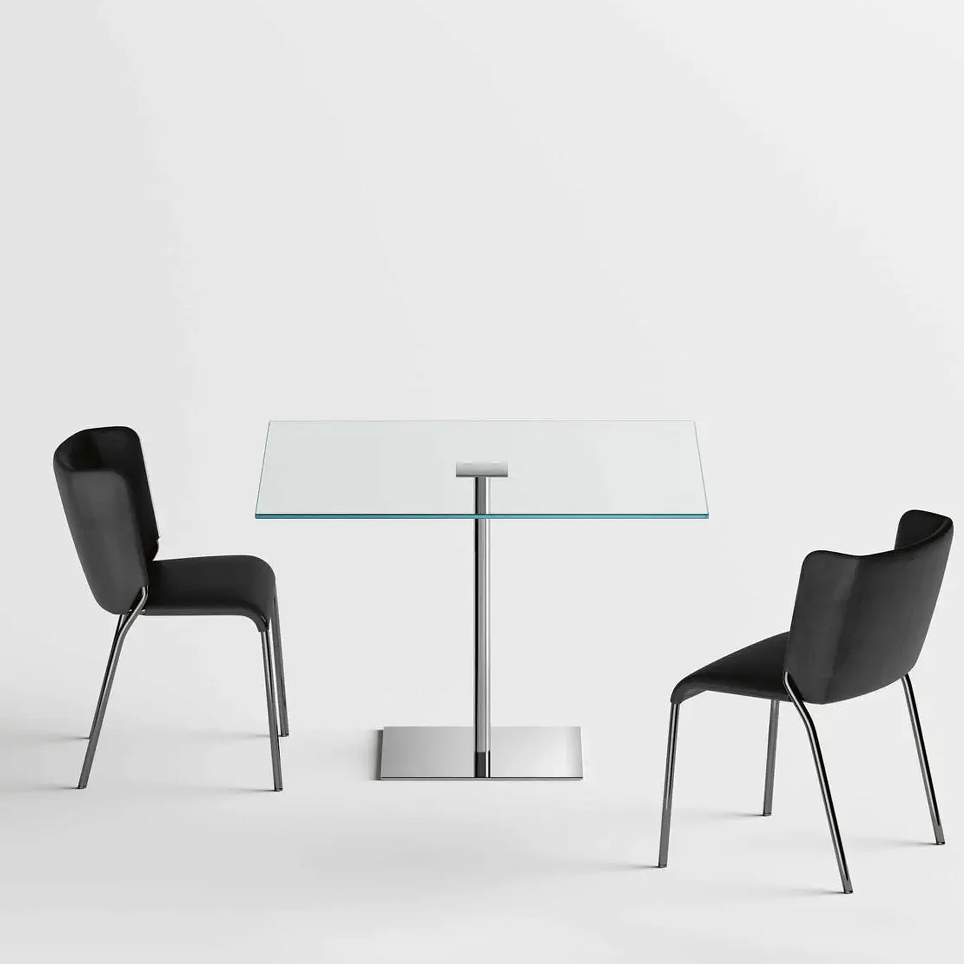 Contemporary glass dining table with two black chairs, ideal for modern interiors.