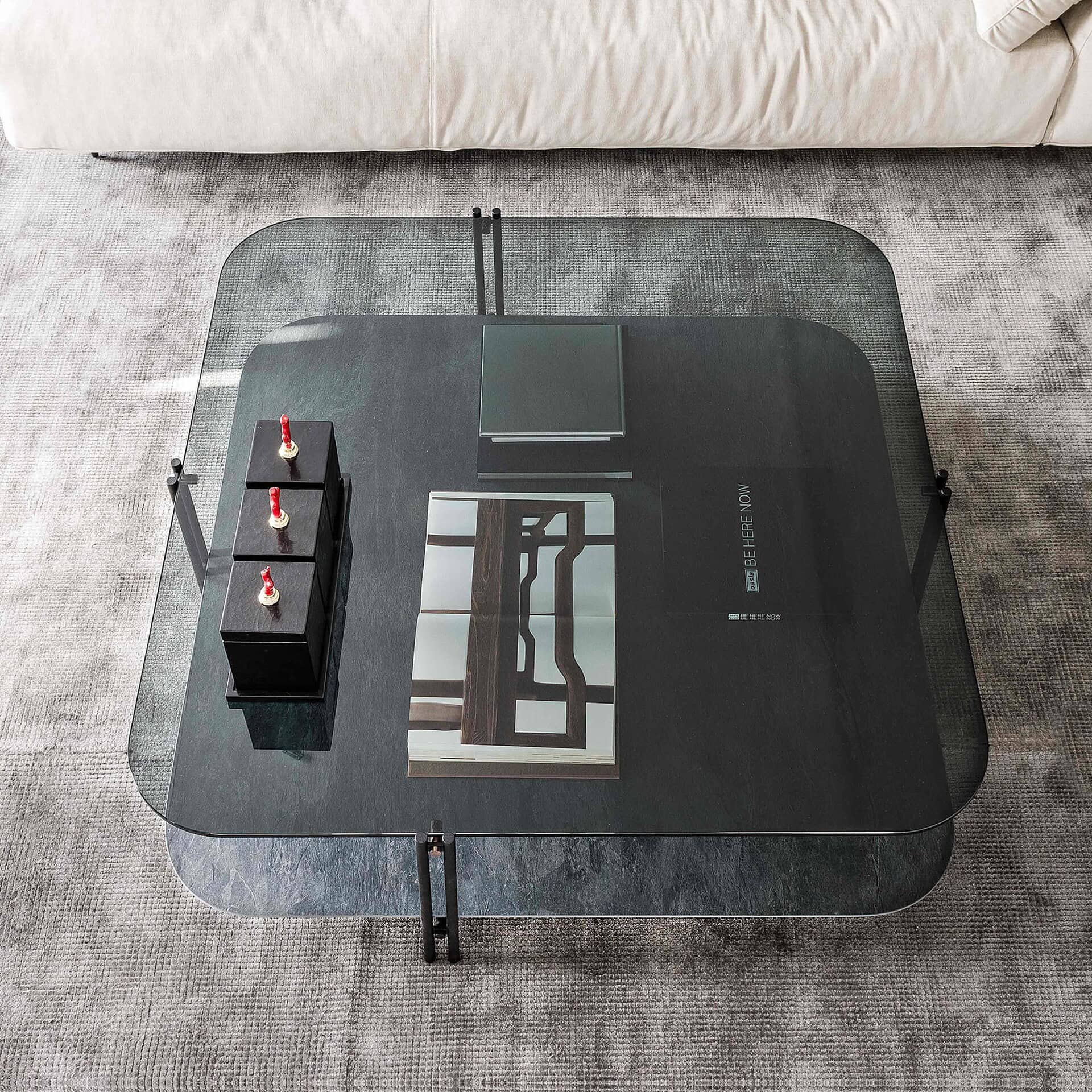 Sleek glass coffee table with metal frame, modern design, in a contemporary living room setting.