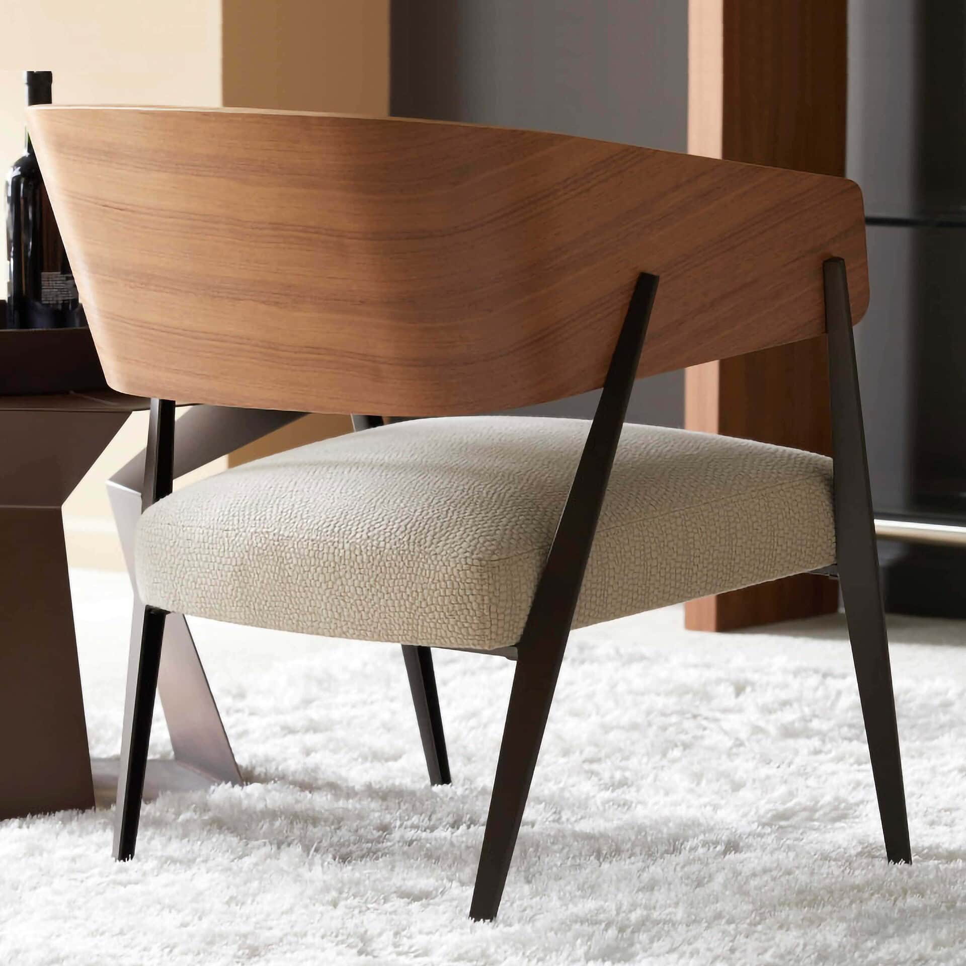 Contemporary wooden accent chair with black angled legs and neutral upholstered seat for modern living spaces.