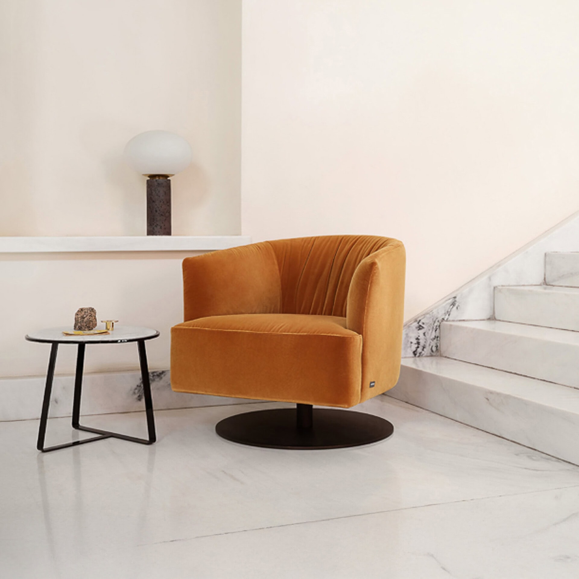 Mustard velvet swivel chair with rounded backrest and black base.