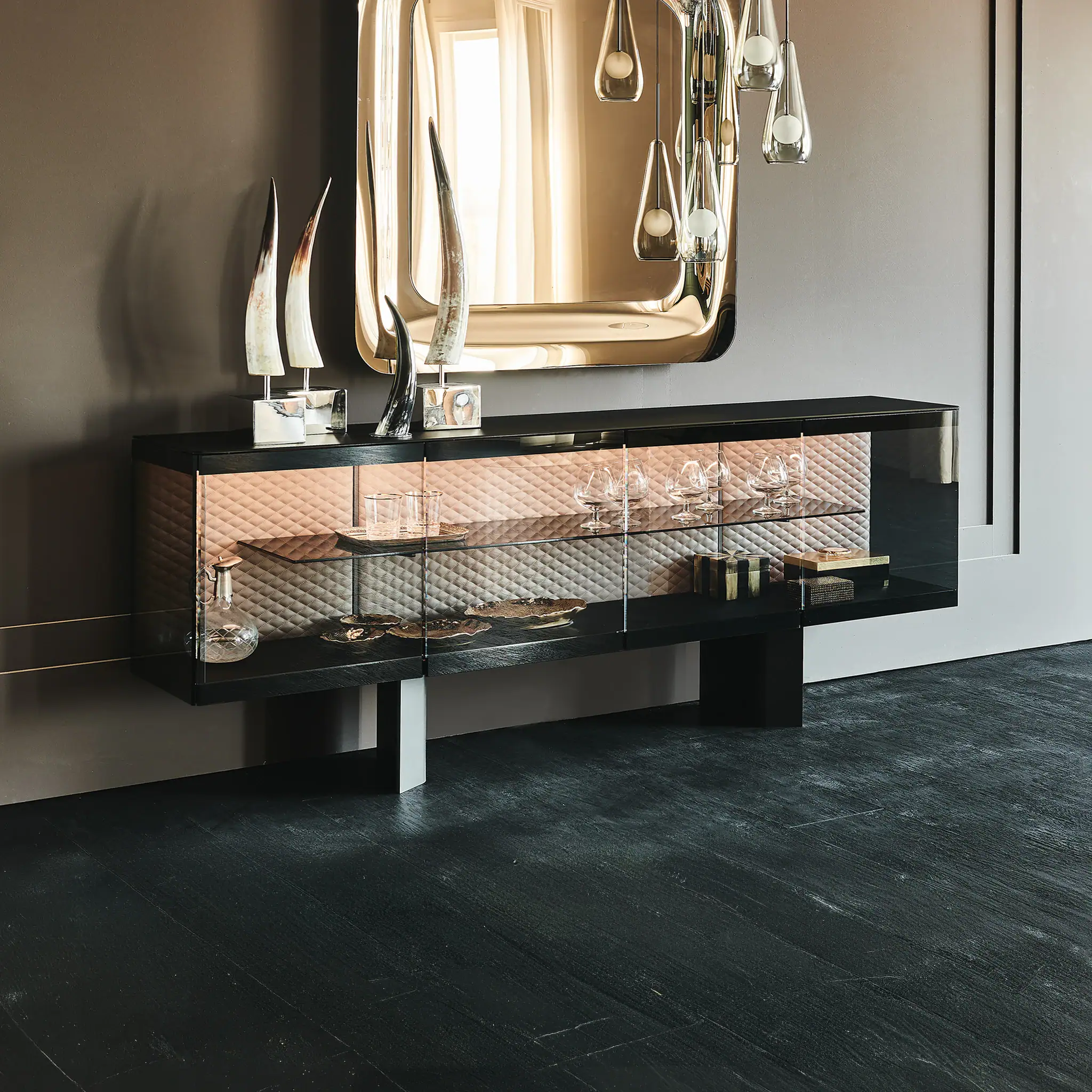 Modern black sideboard with glass doors and decorative items.