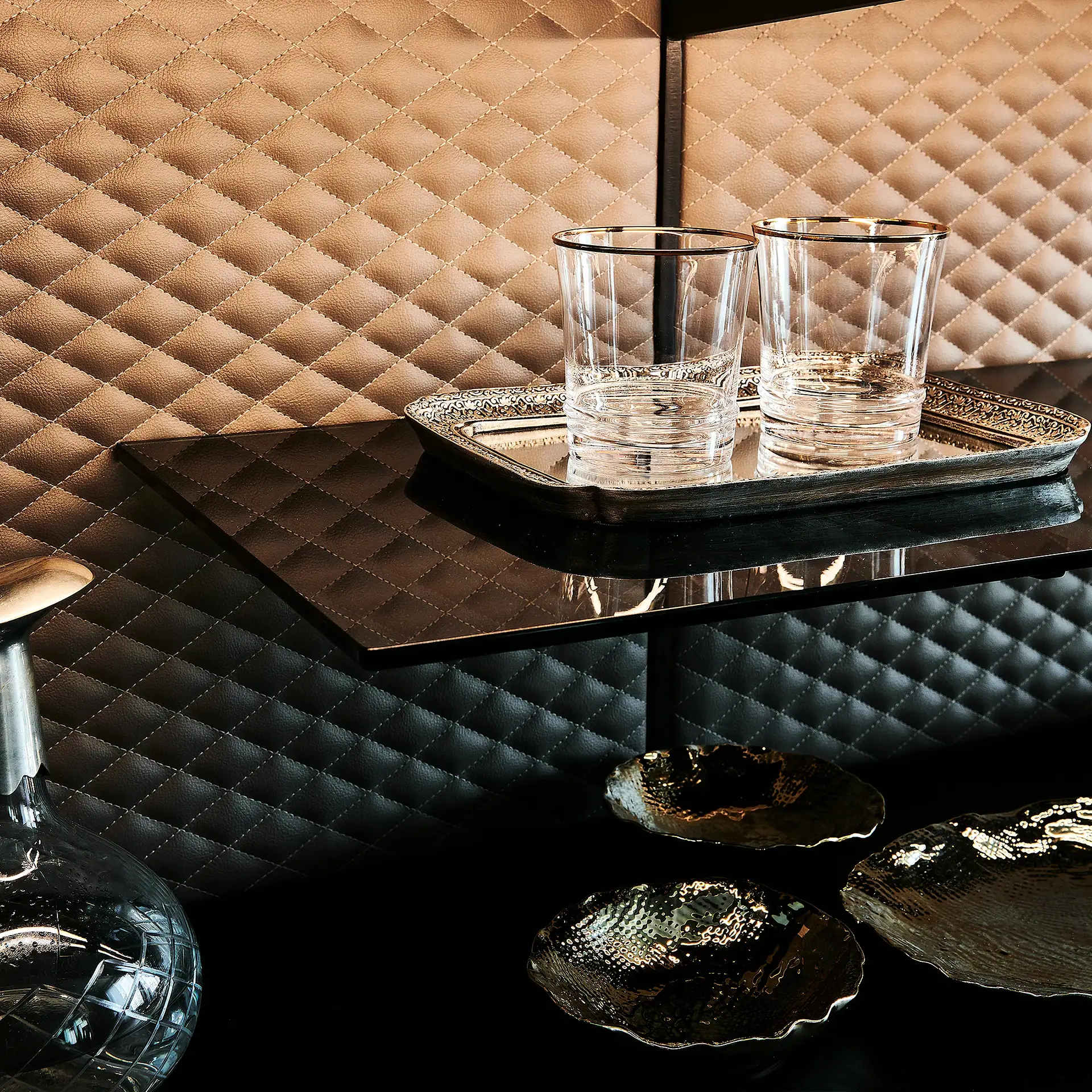 Modern sideboard with glassware and decorative trays in a stylish setting.