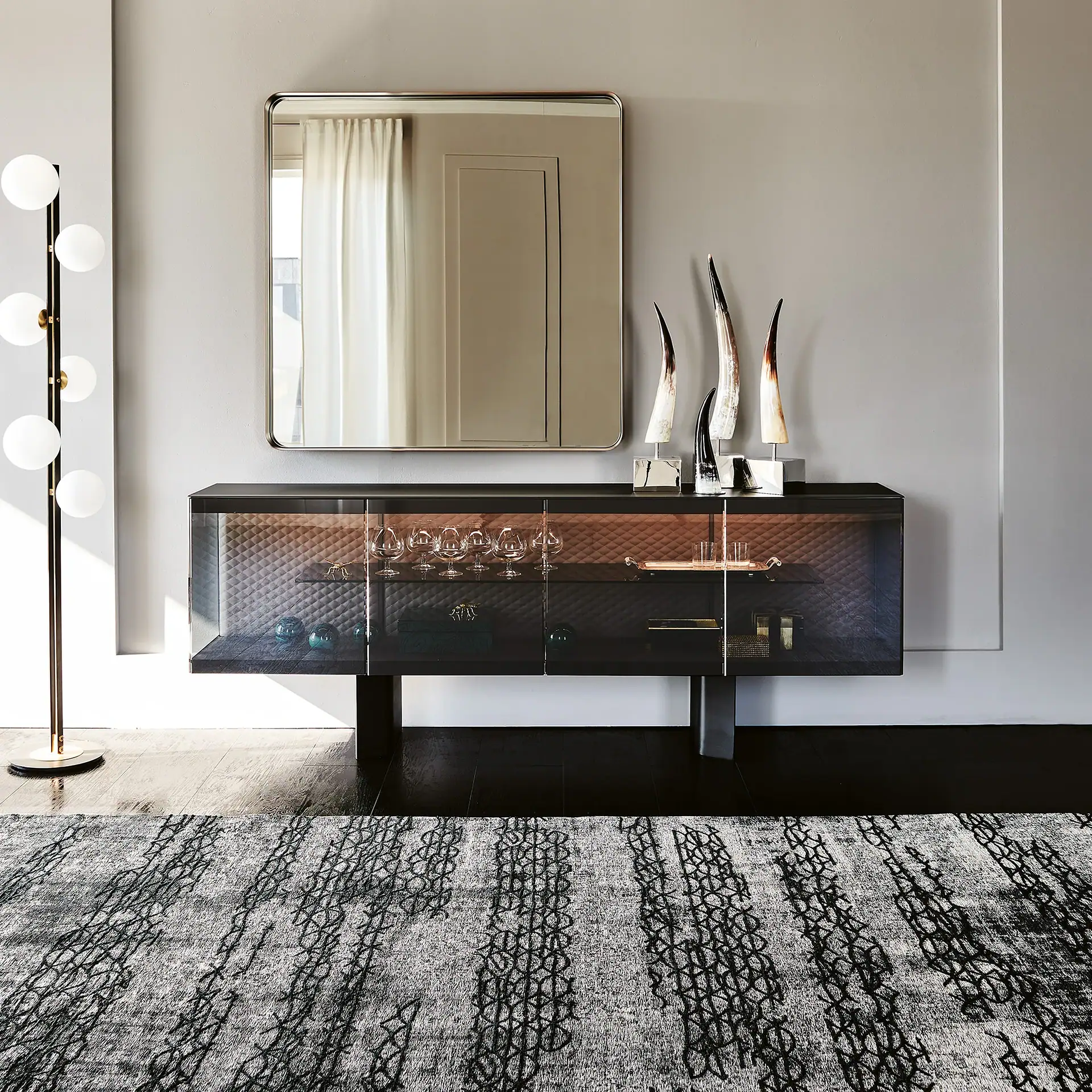 Elegant black sideboard with glass doors and decorative sculptures.