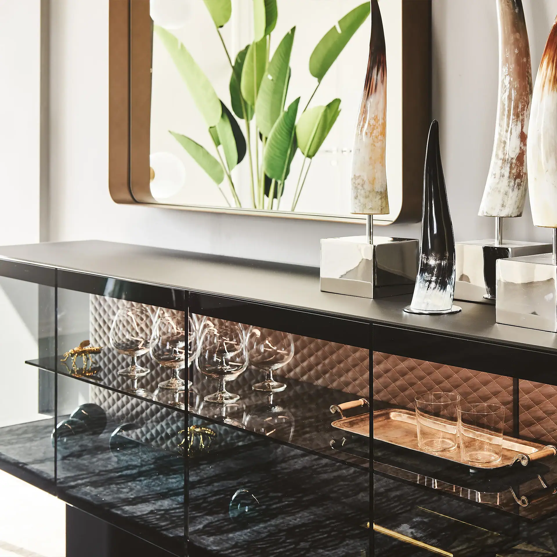 Contemporary sideboard with glass doors and decorative vases and tray.