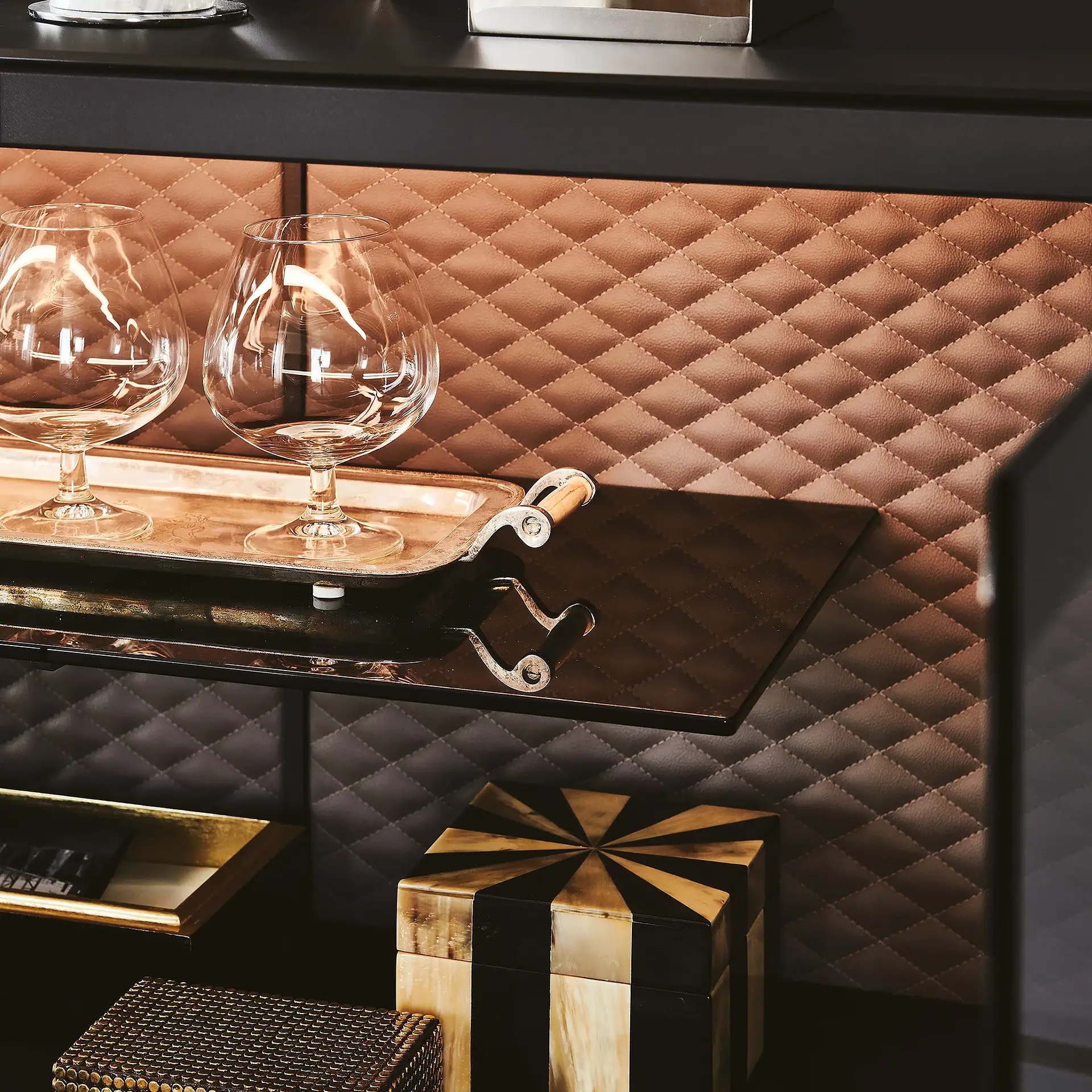 Elegant sideboard with glassware and decorative box in modern interior.