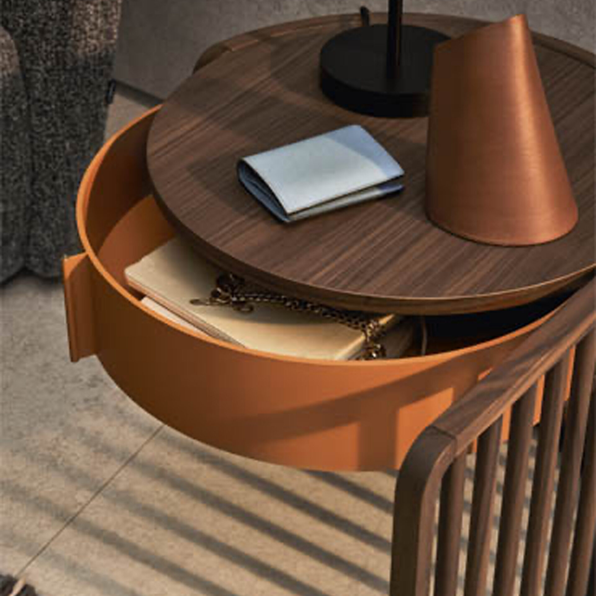 A modern side table with a dark wood top and an open terracotta storage compartment. On the top, there's a folded light blue item and a copper cone. Inside the compartment, a book and a gold chain are visible.
