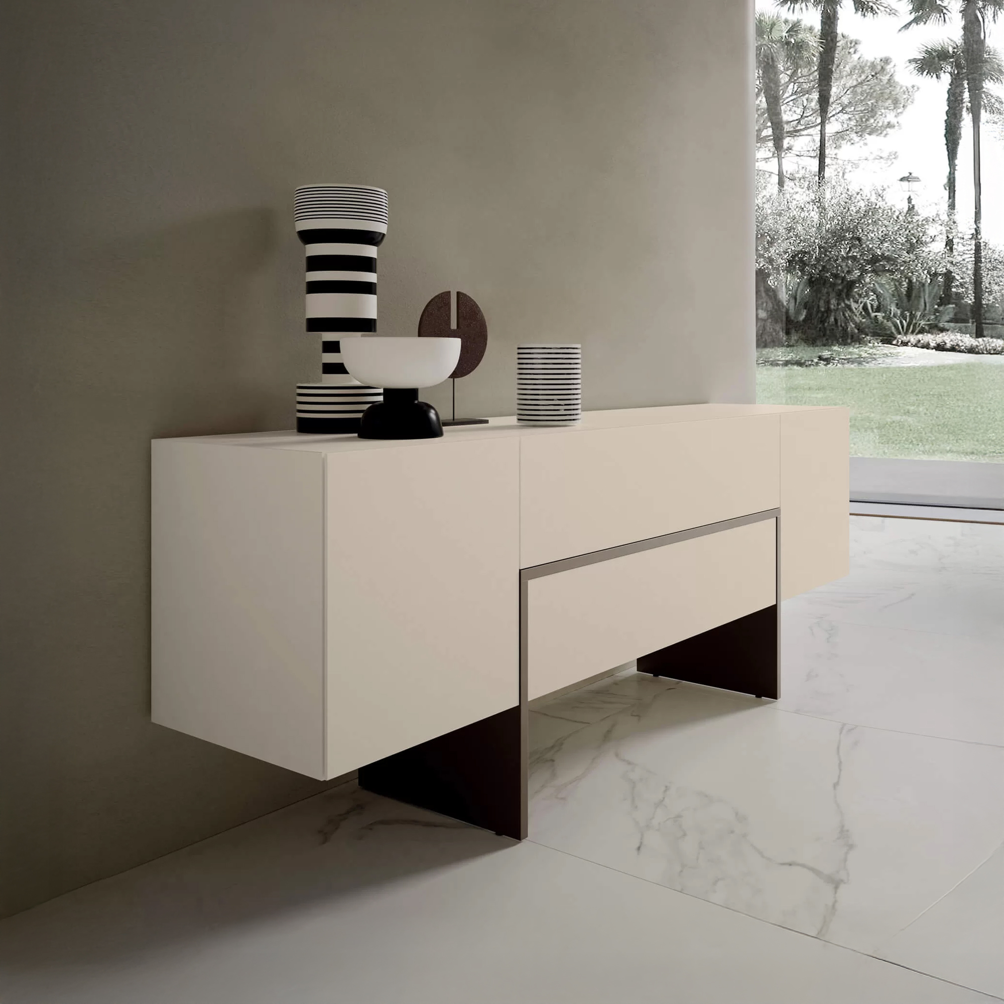 A modern light beige sideboard with black and white striped decor against a grey wall, overlooking a lush garden with palm trees through a large window.